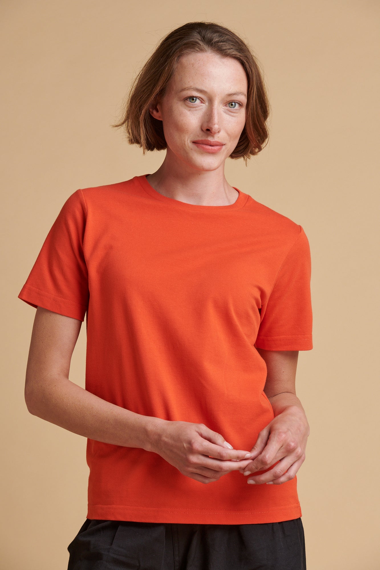 Female wearing breathable t shirt in flame red.