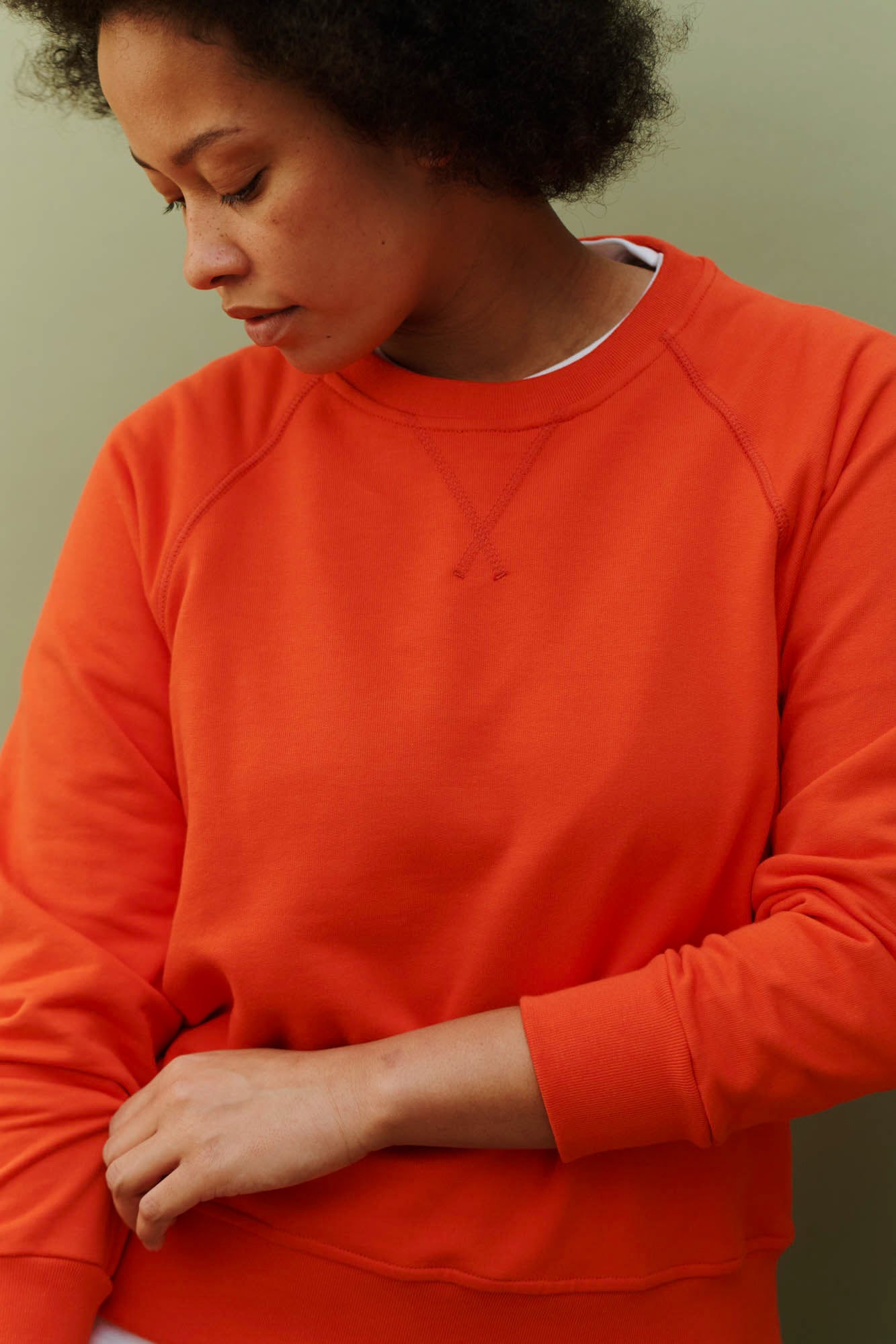 Female wearing raglan sweatshirt in flame red