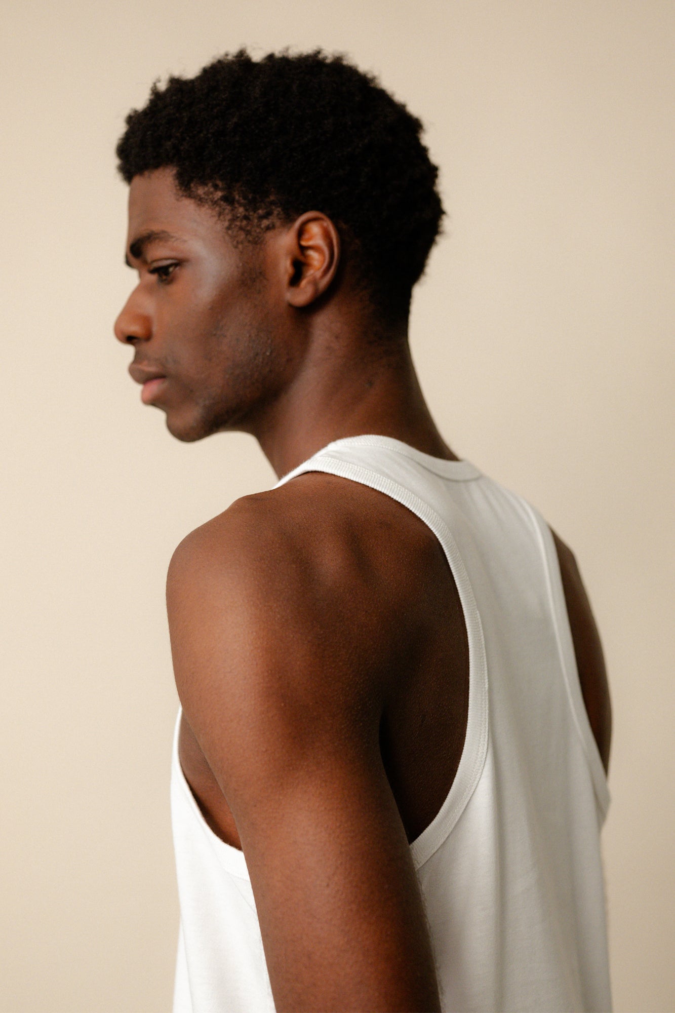 Back/side angle of black male showing the racer back of vest in white