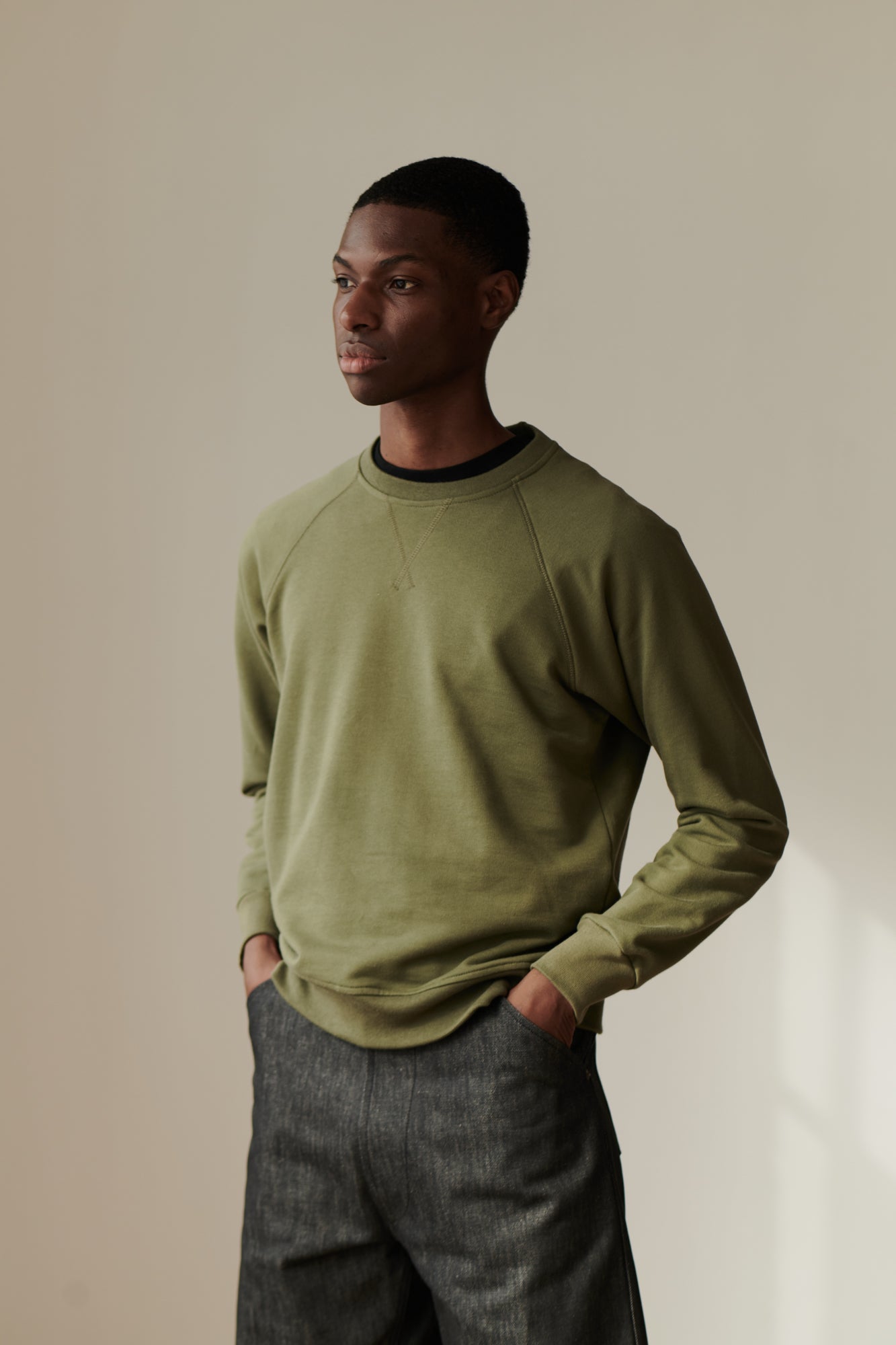 Front image of male wearing raglan sweatshirt in olive