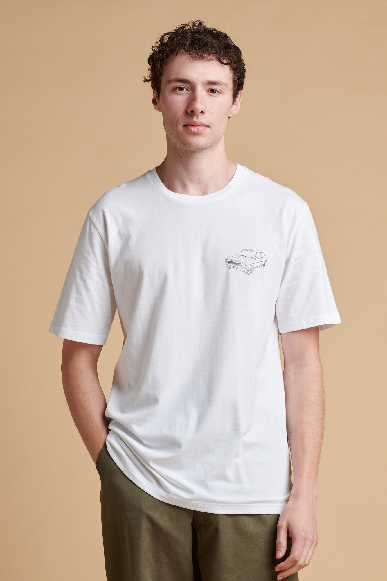 Male wearing short sleeve graphic t shirt in white with Fiesta car print.