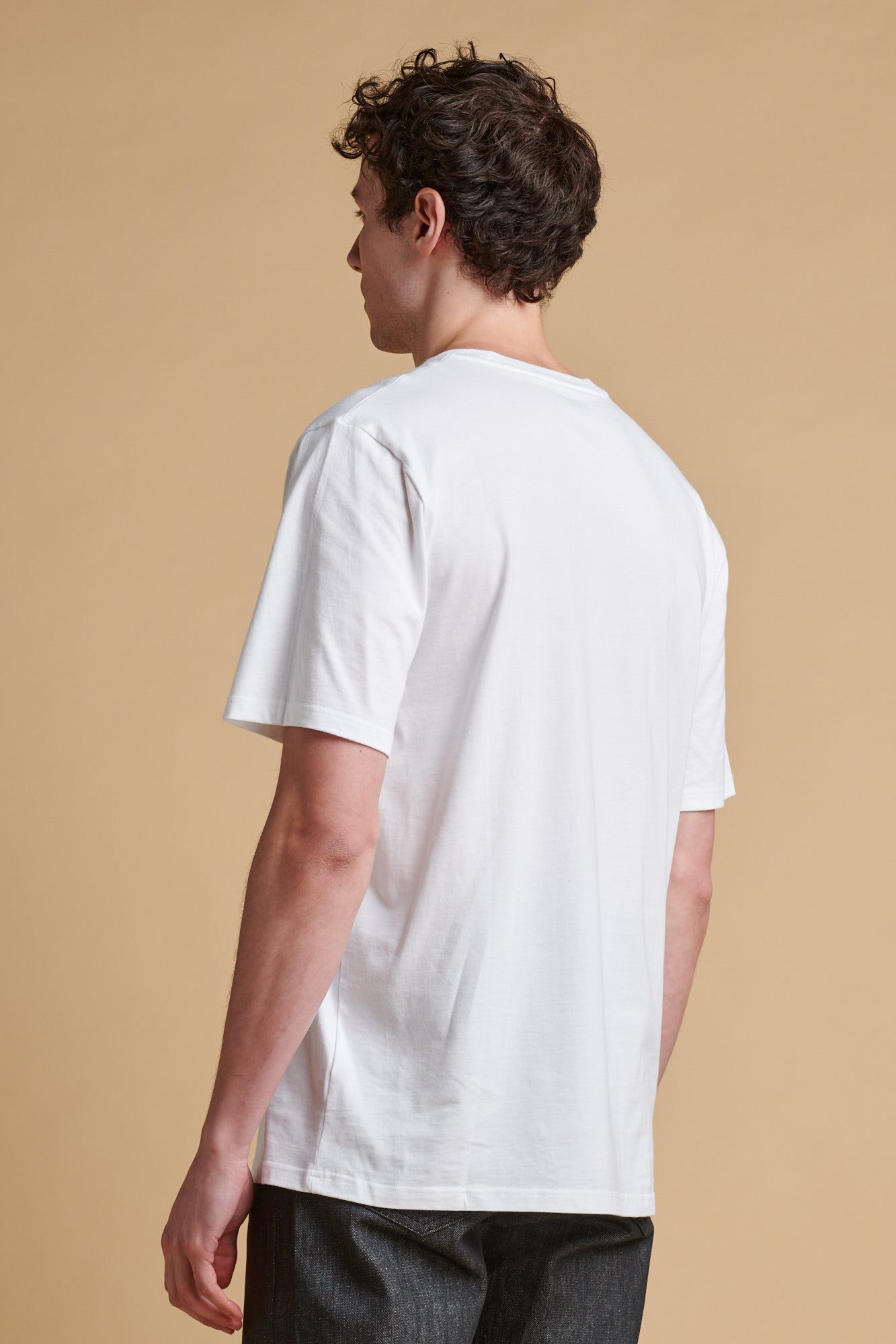 The back of male wearing short sleeve graphic t shirt.