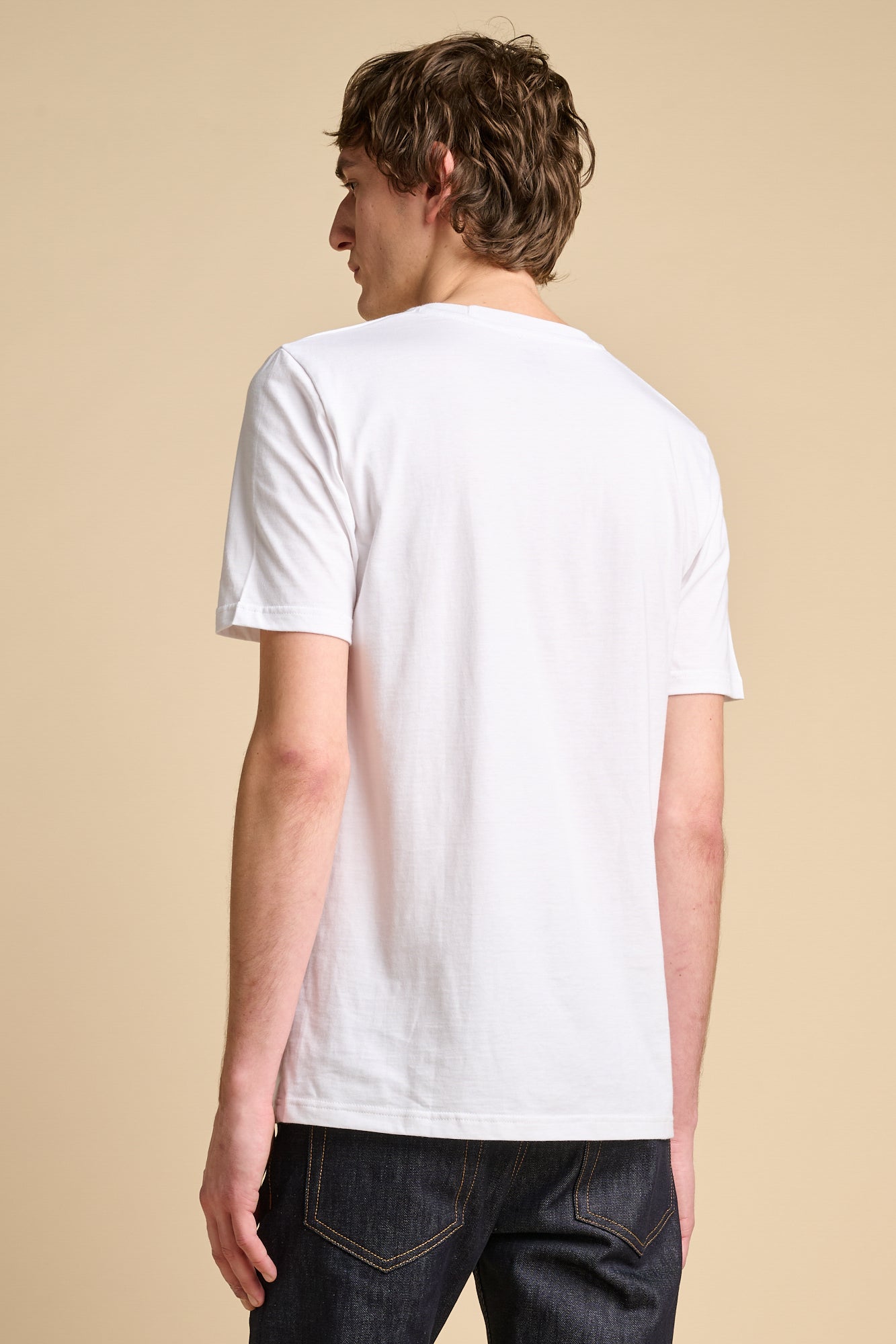 The back of male wearing short sleeve white t shirt.