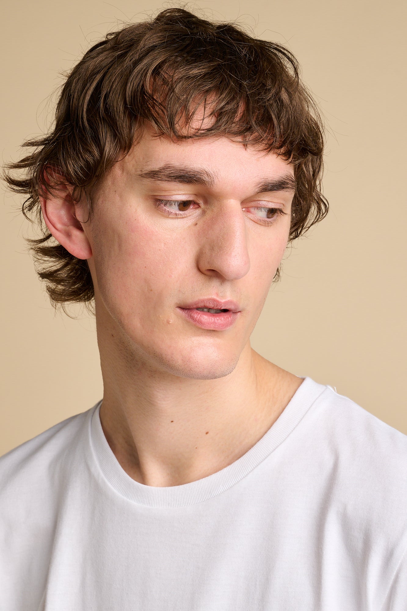 Portrait of man wearing crew neck white t shirt.