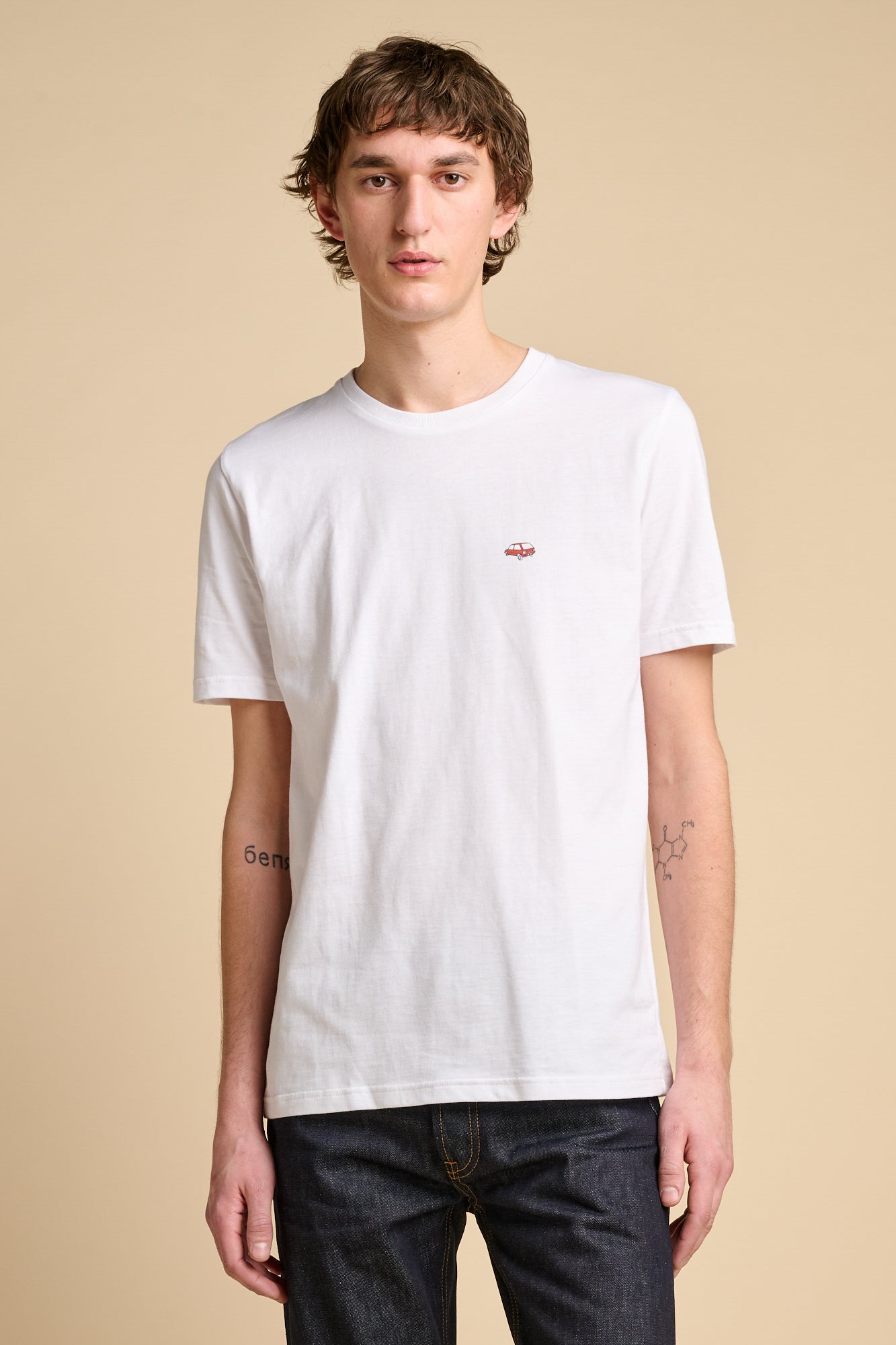 Smiling man wearing short sleeve white t shirt with graphic print.