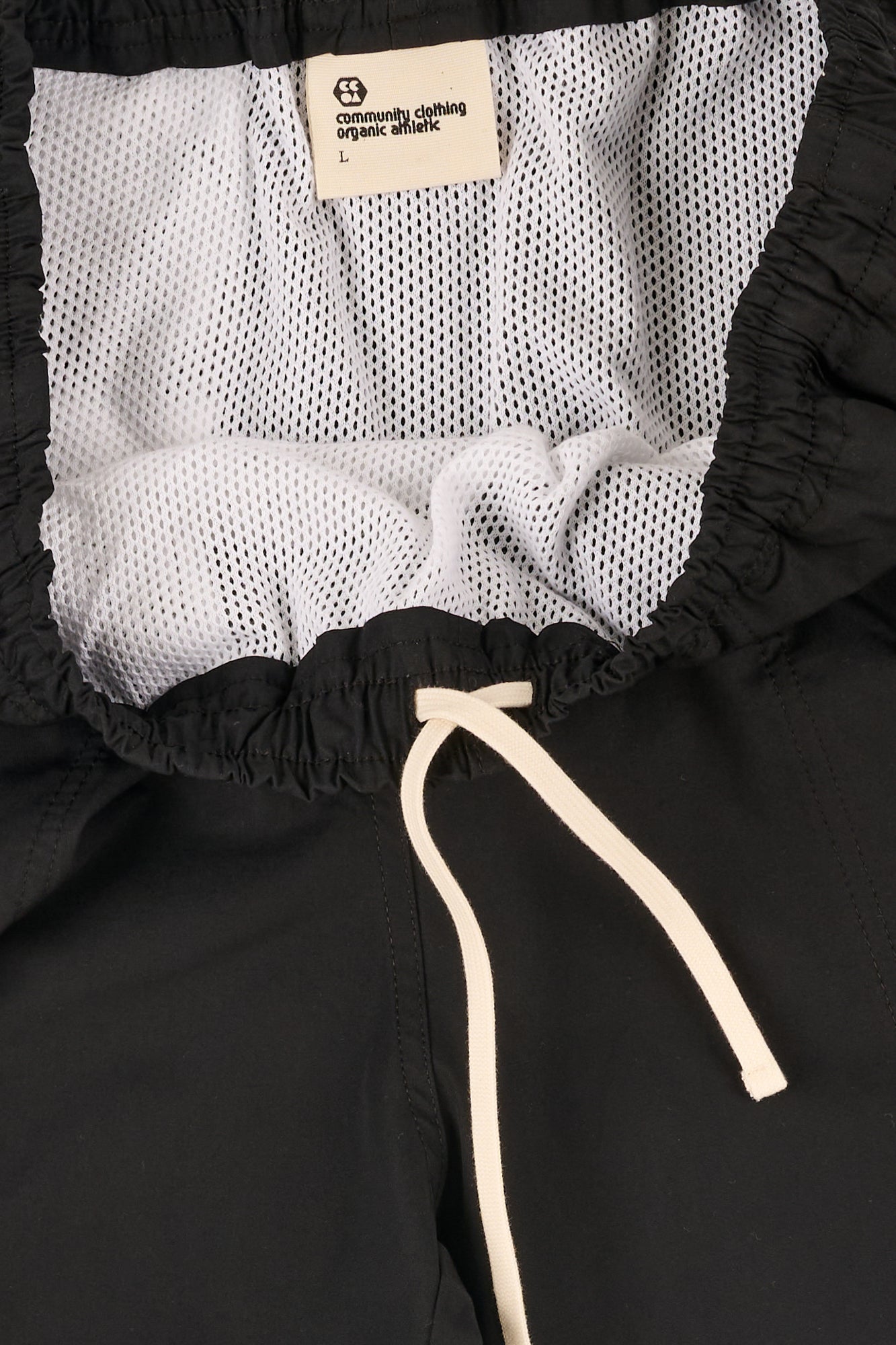 Close-up of a black shorts with an ecru drawstring.