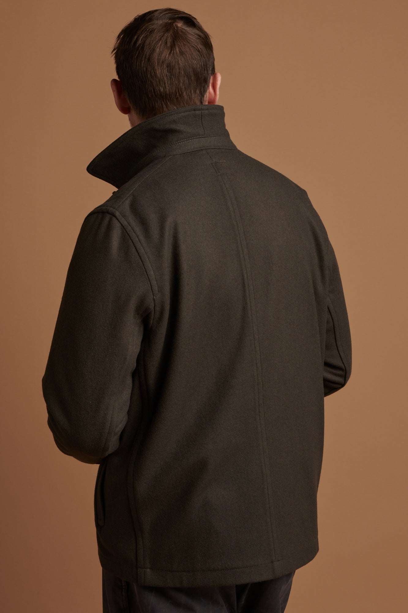 The back of Patrick wearing Drab Arthur wool chore jacket with collar up.