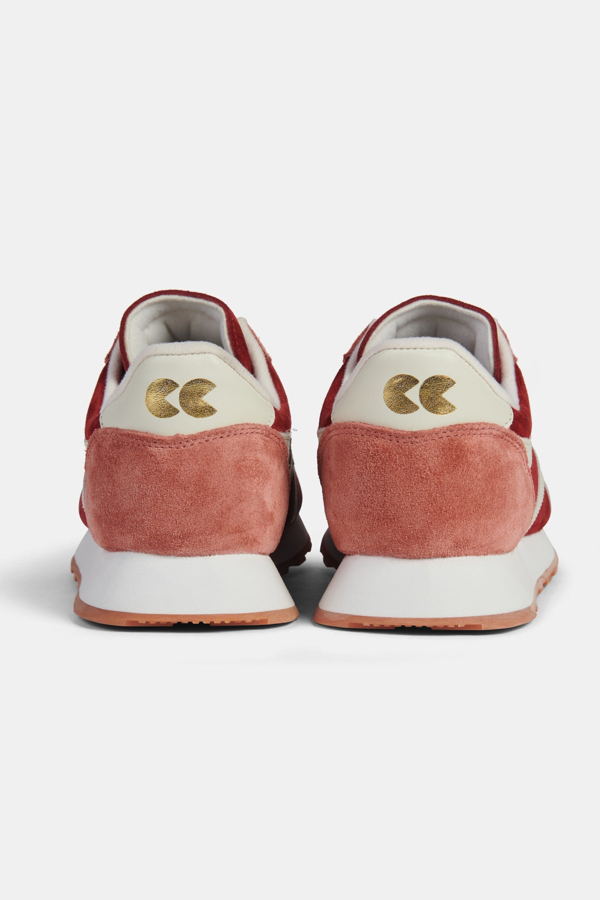 Pair of red and white trainers on a  white background. 