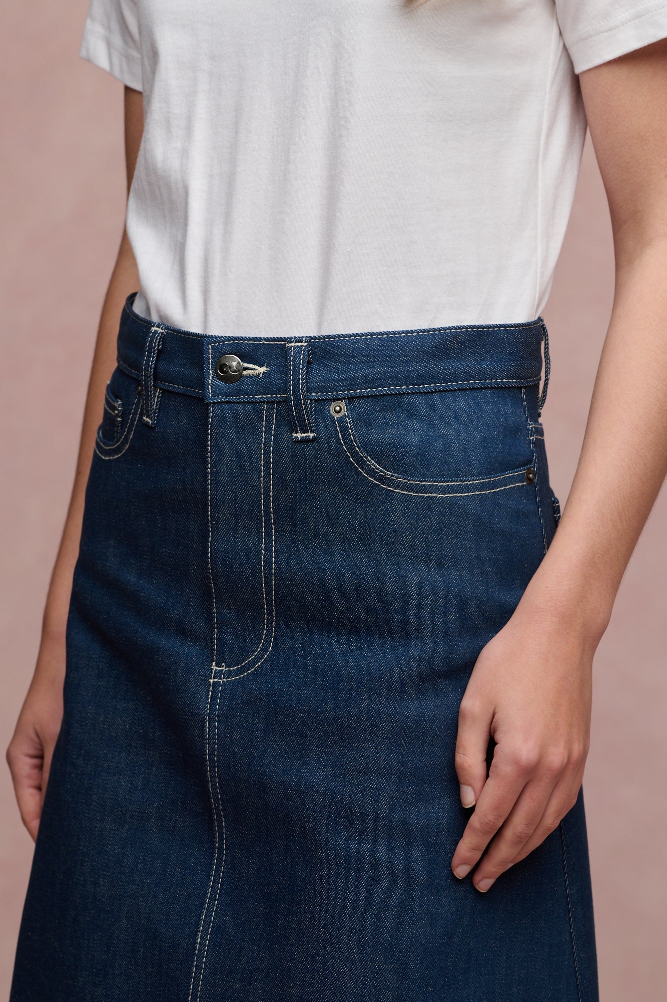 Close up of the front waistband and two front pockets of Bobbie a line denim skirt in blue