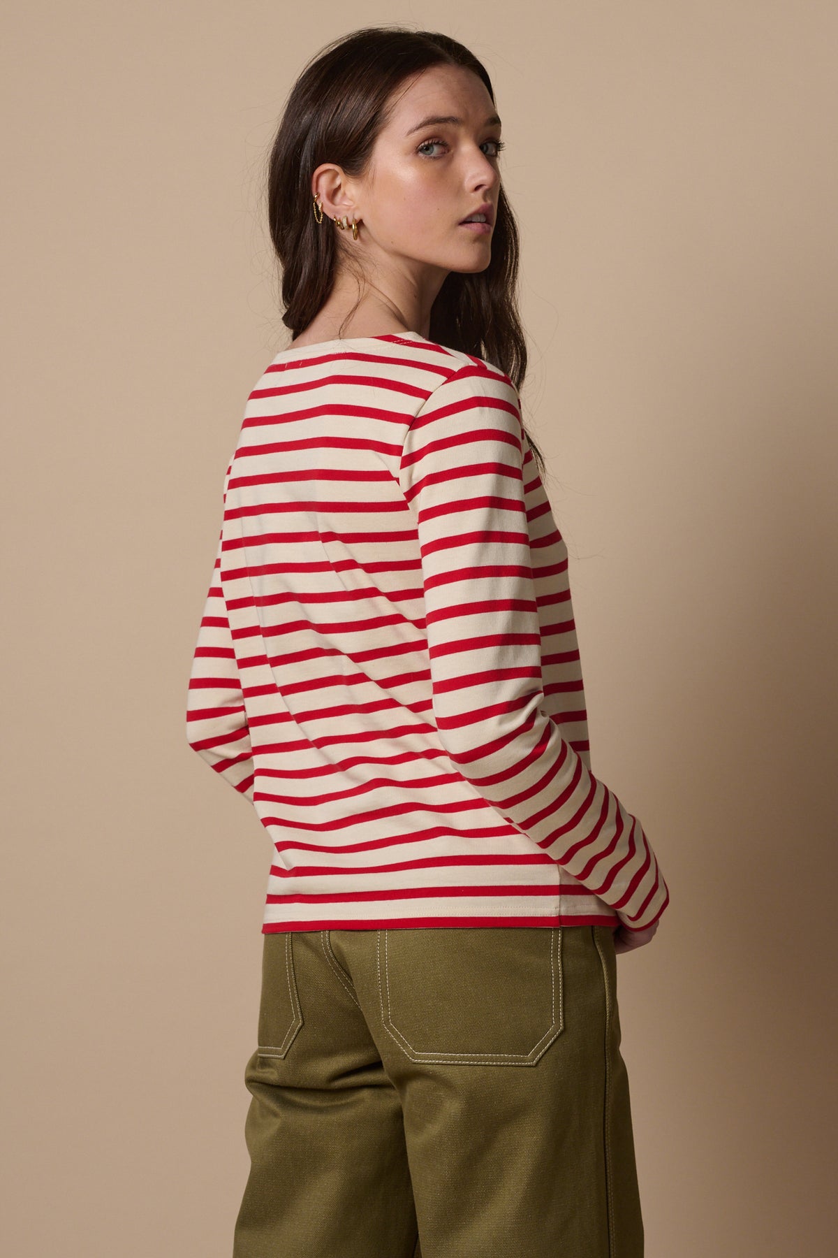 The back of white female with long brunette hair wearing Breton in ecru and red