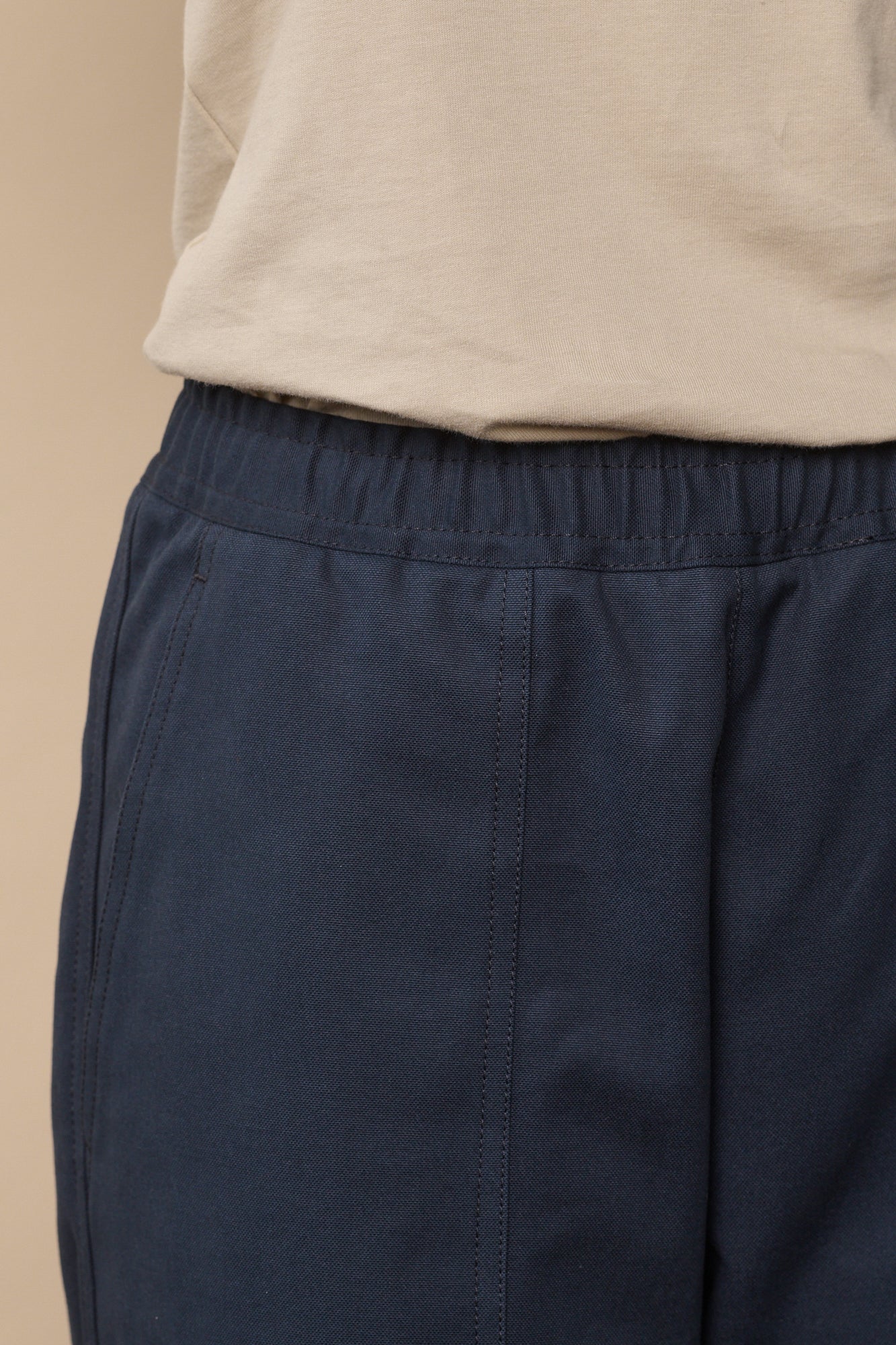 Drawstring waistband and front pocket detail of camerawoman trousers