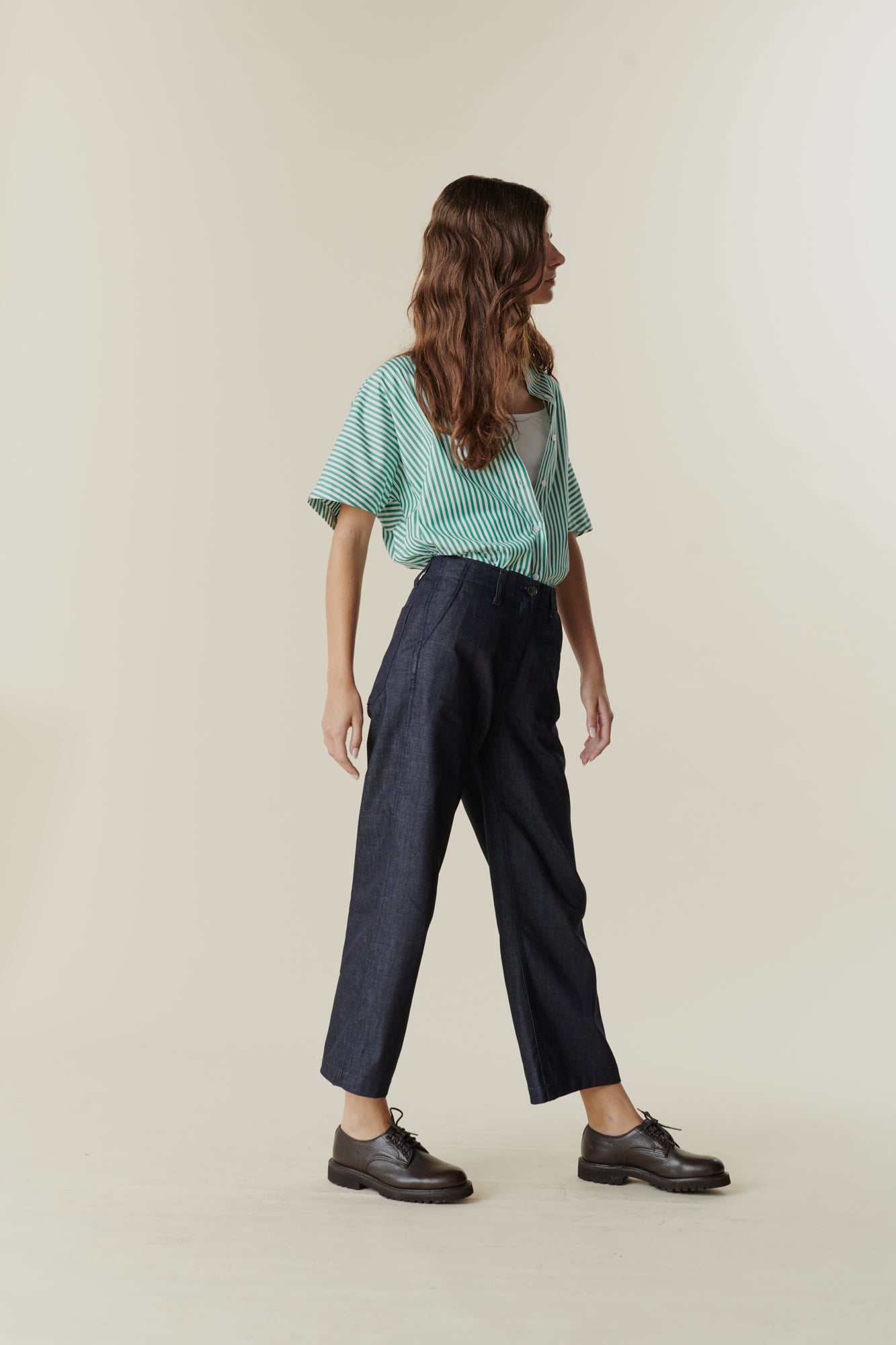 Side view of female wearing cropped work trousers in denim 