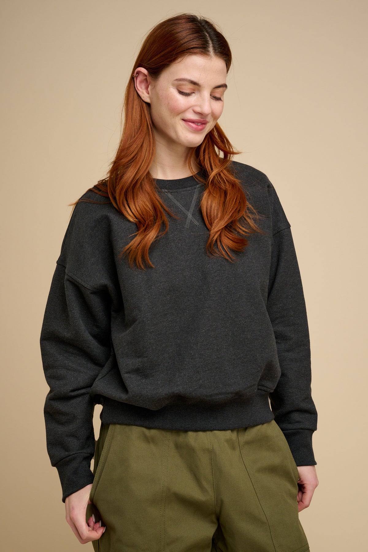 Woman wearing charcoal heavyweight sweatshirt  with olive trousers