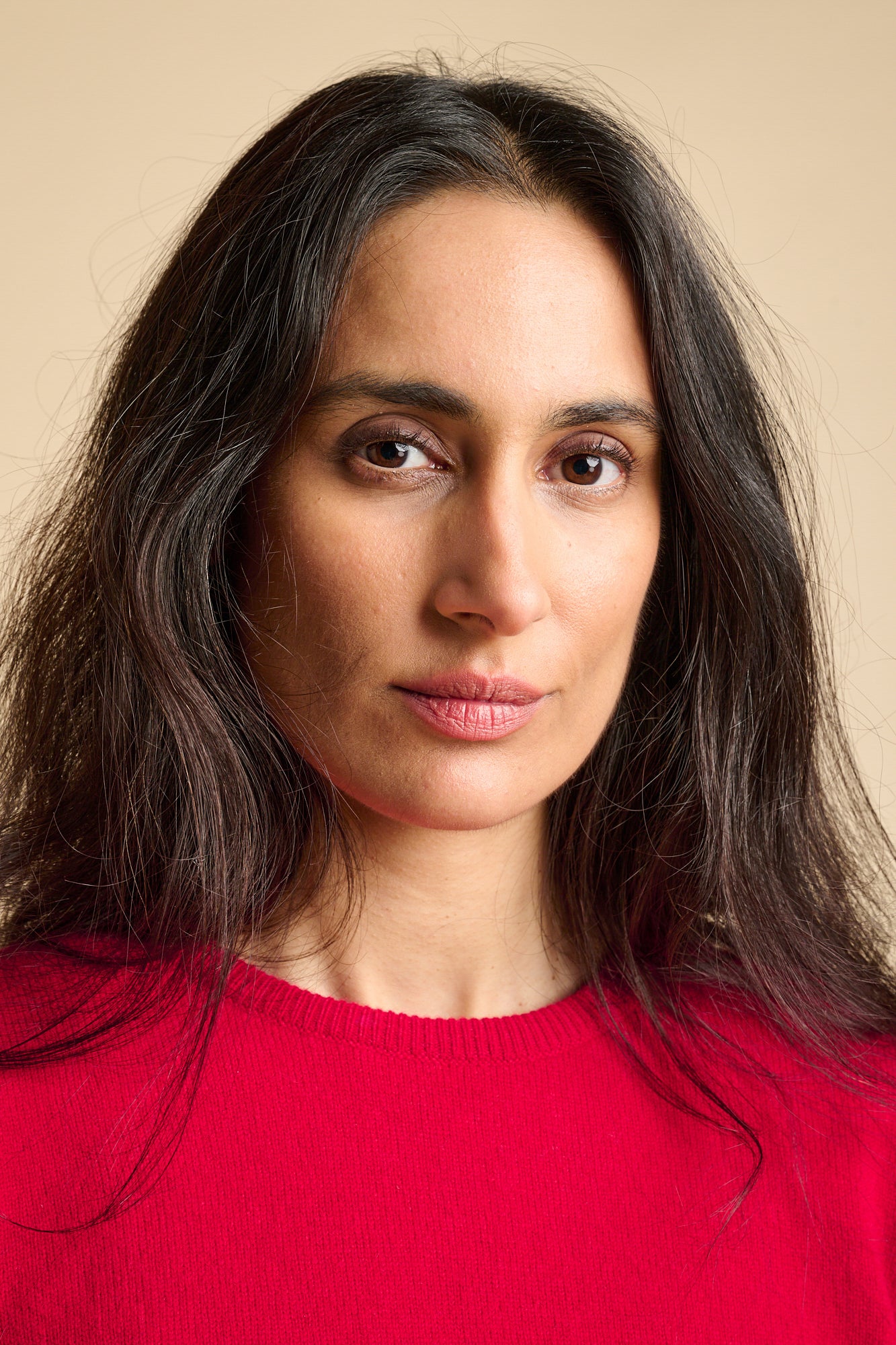 Portrait of a woman wearing lambswool red crew neck jumper.