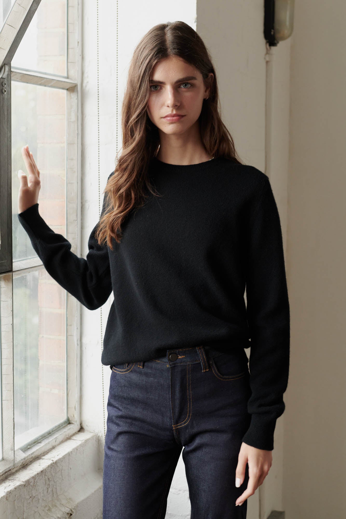 Brunette female wearing lambswool crew neck in black