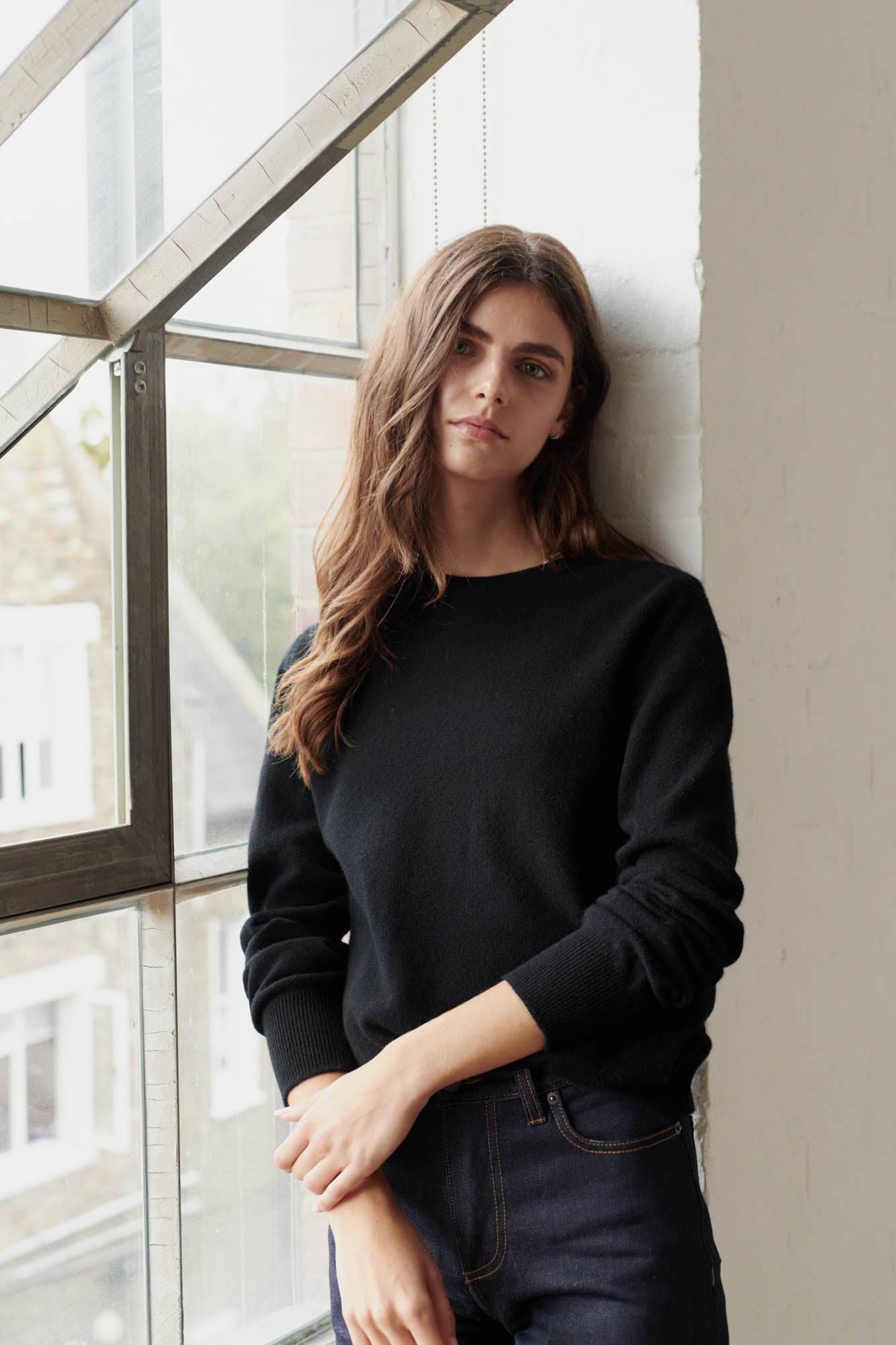 Brunette female wearing lambswool crew neck in black