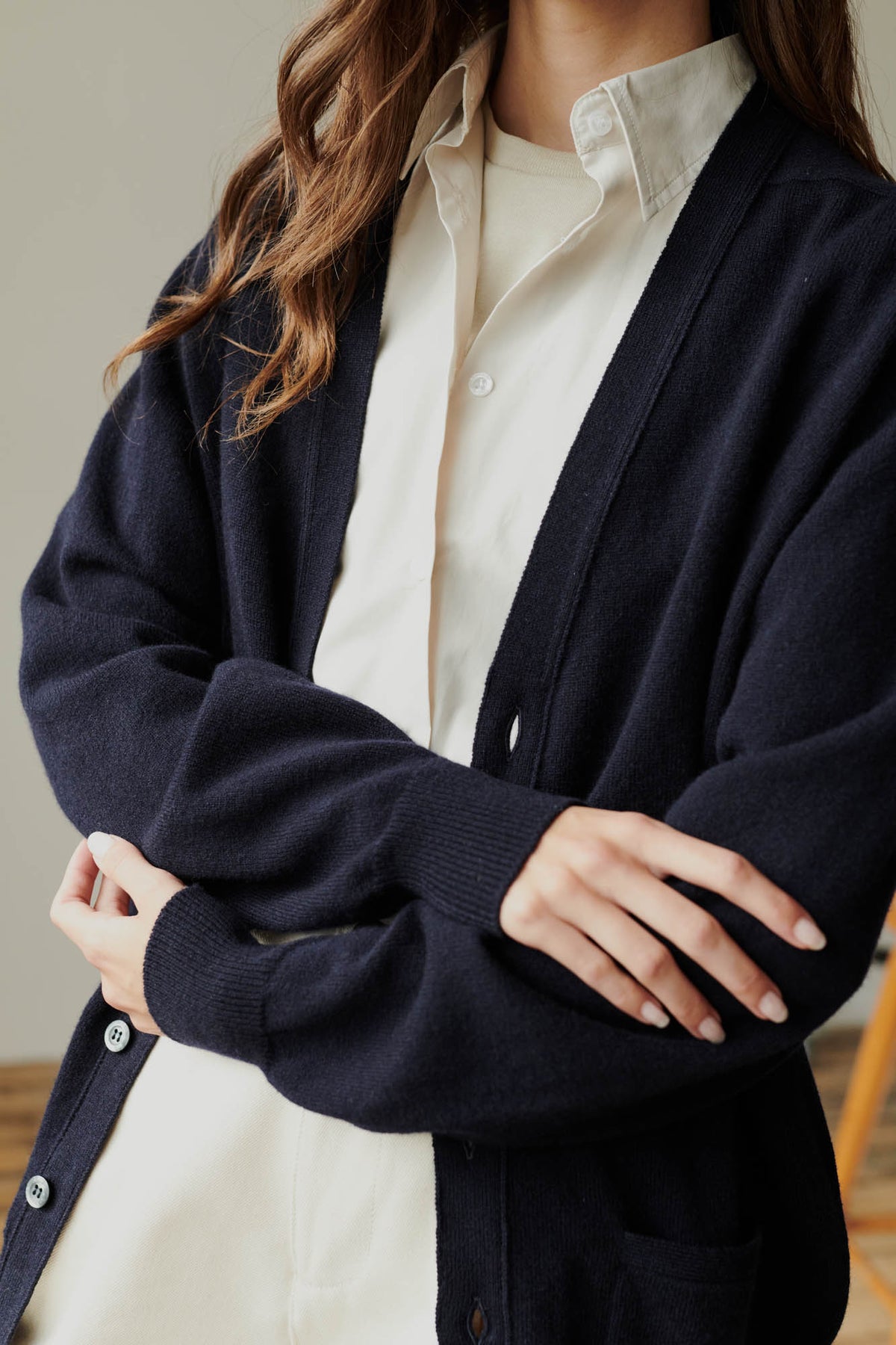 Brunette female wearing unbuttoned lambswool v neck cardigan