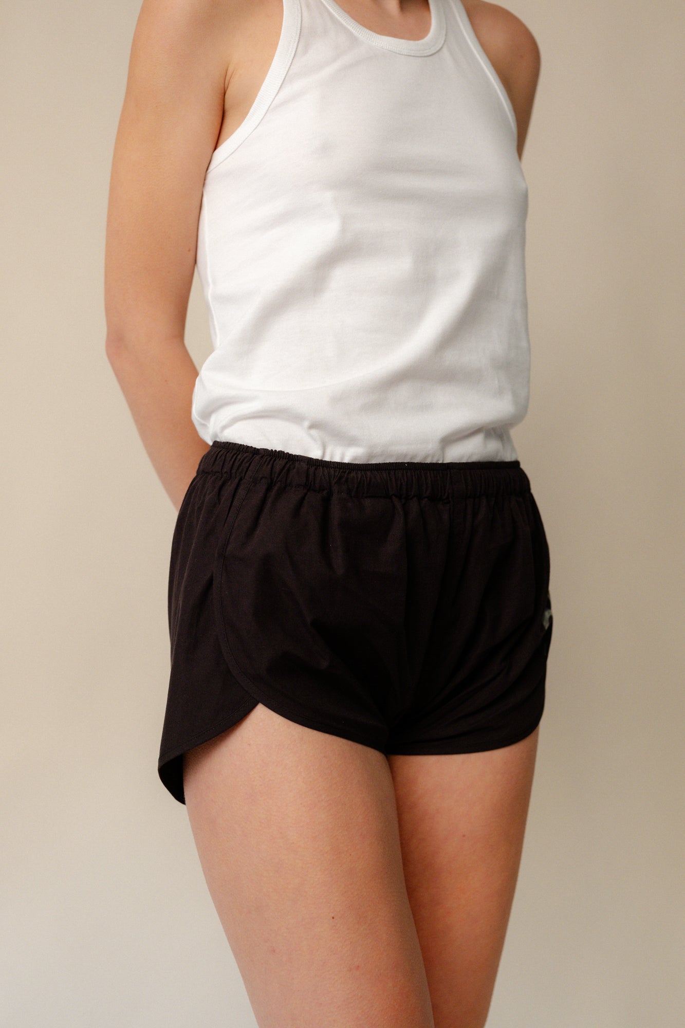Image of white female thigh up to shoulder wearing lightweight running short plastic free in black