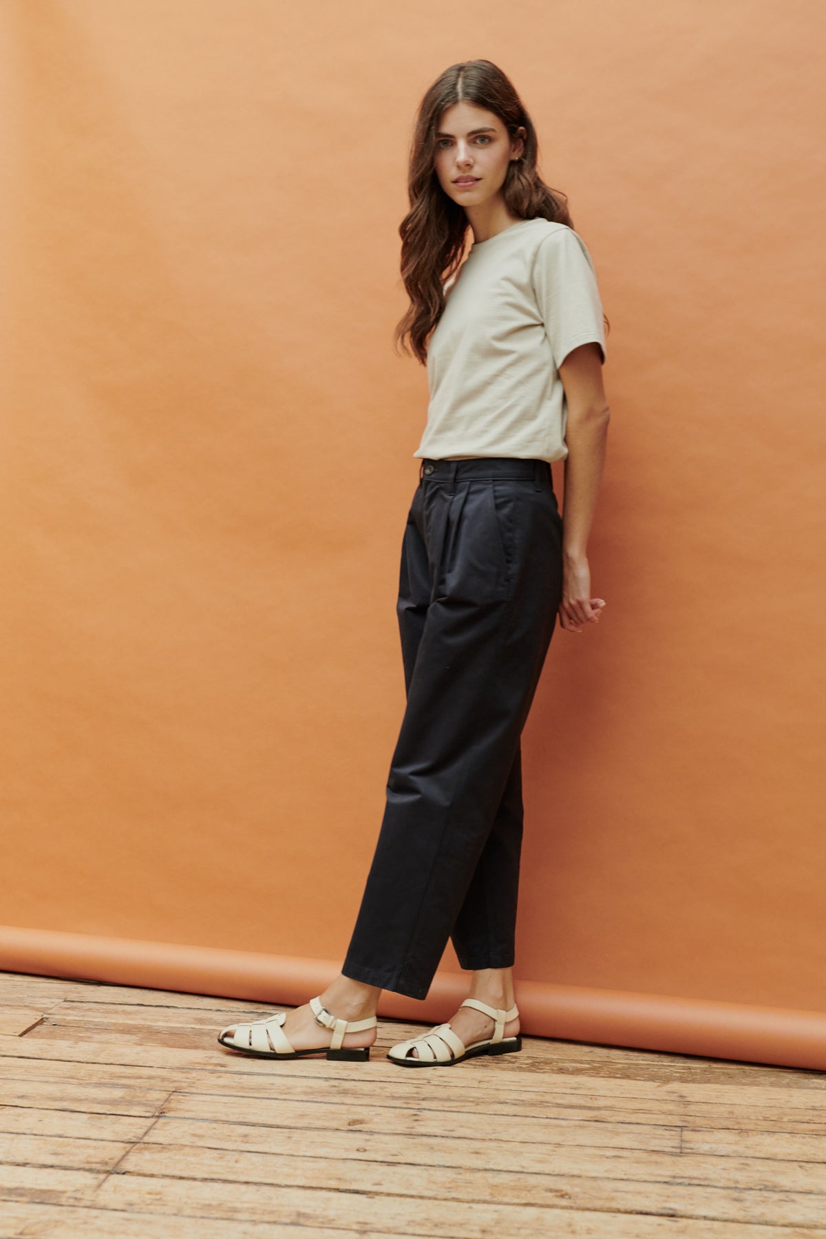 Full body image of female wearing pleated jeans in navy