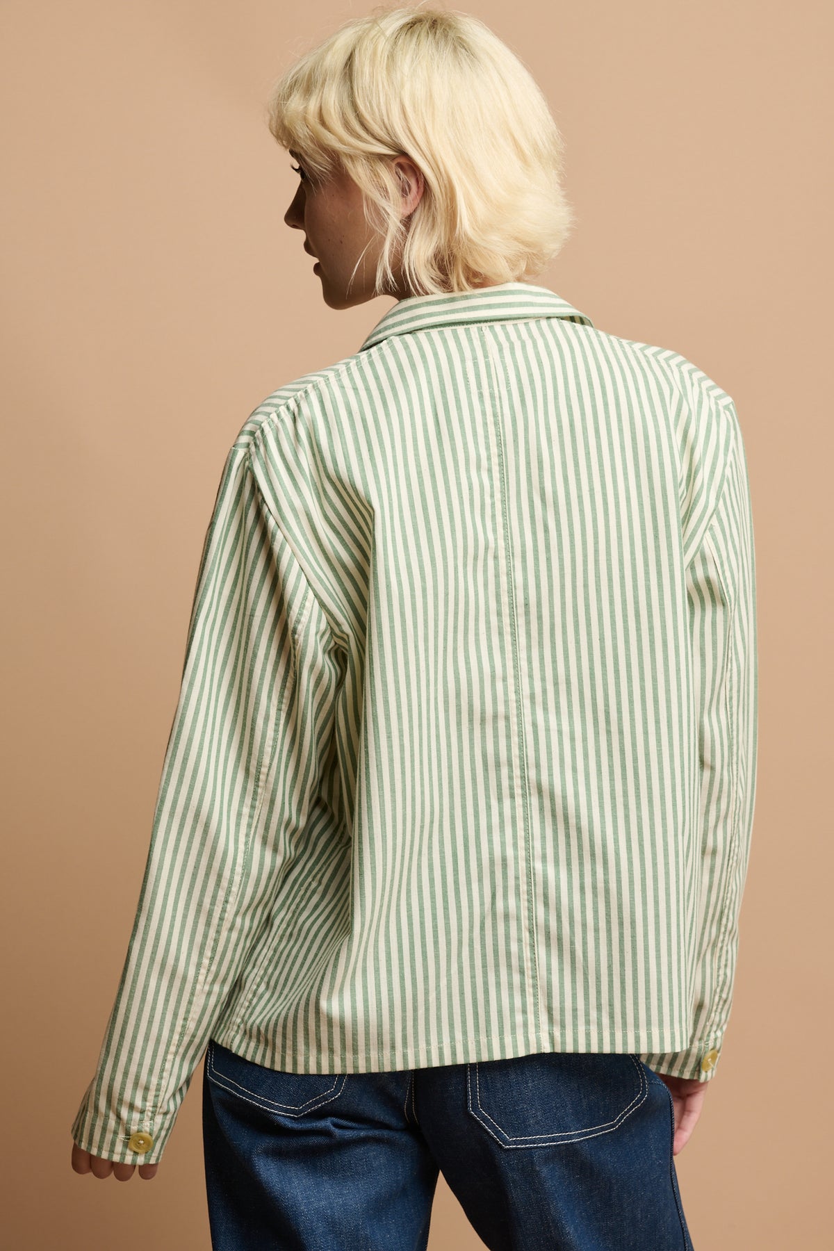 Thigh up of the back of female wearing green and white stripe shirt 