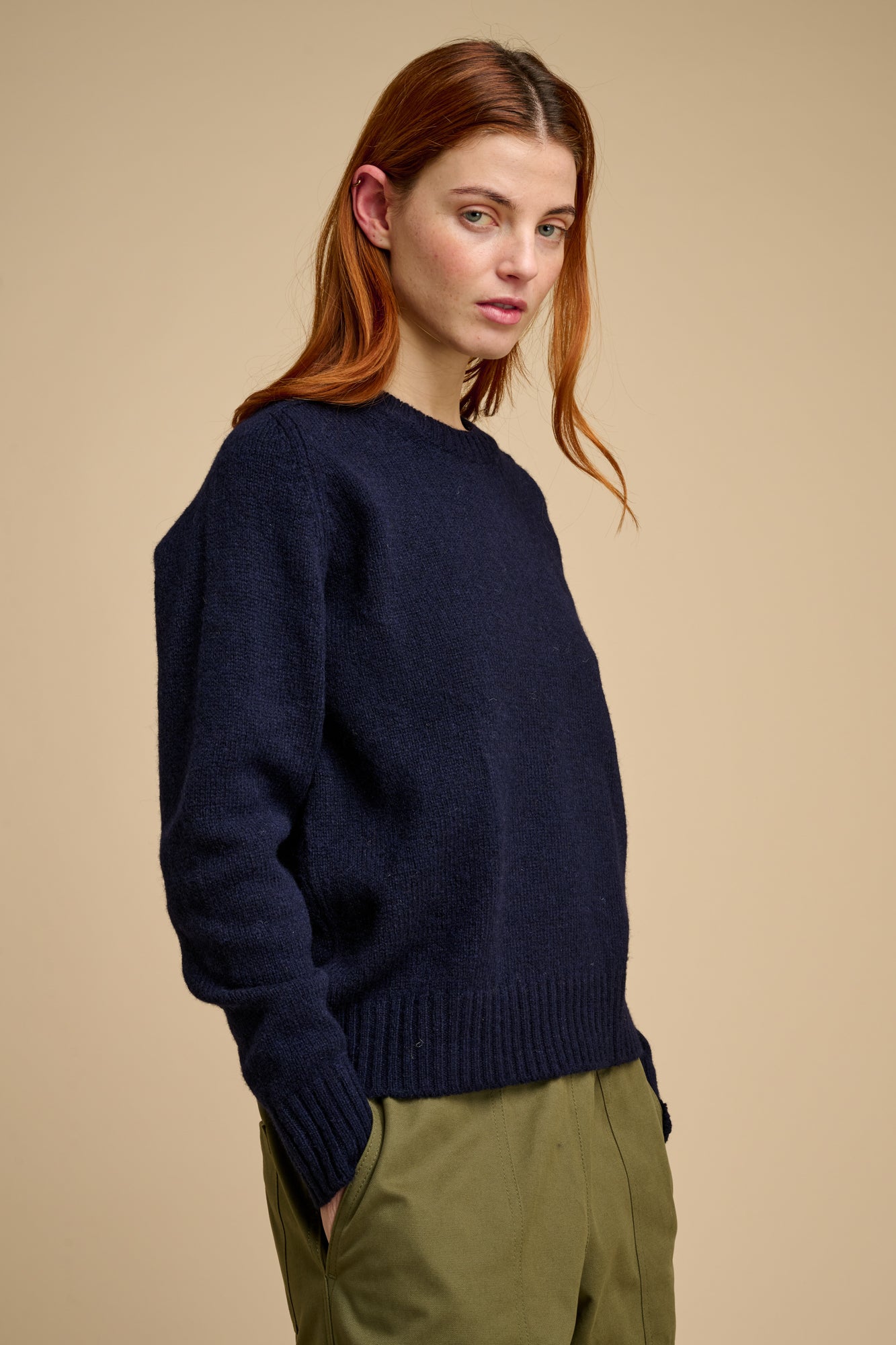 Woman wearing a navy sweater against a beige background