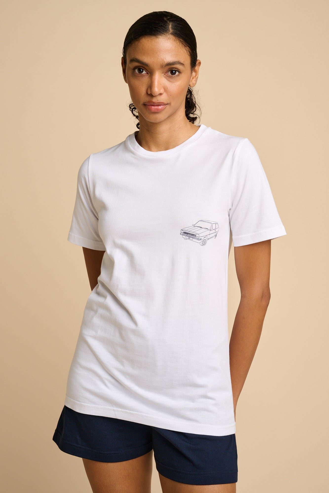 Woman wearing a white t-shirt with a car graphic print.