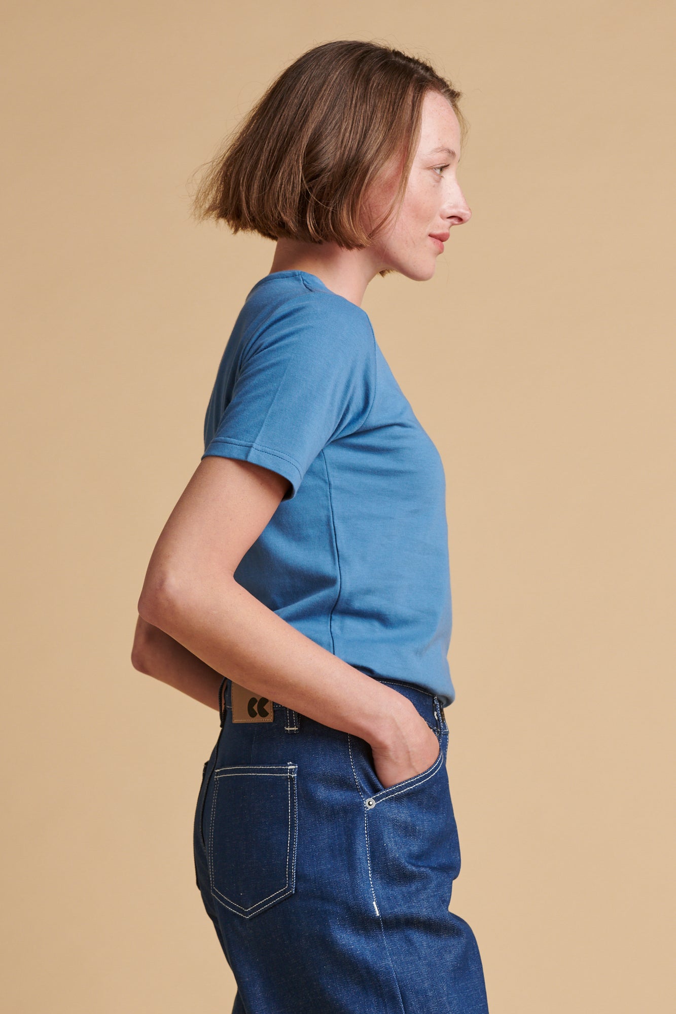 The side of female wearing short sleeve t shirt in RAF blue.