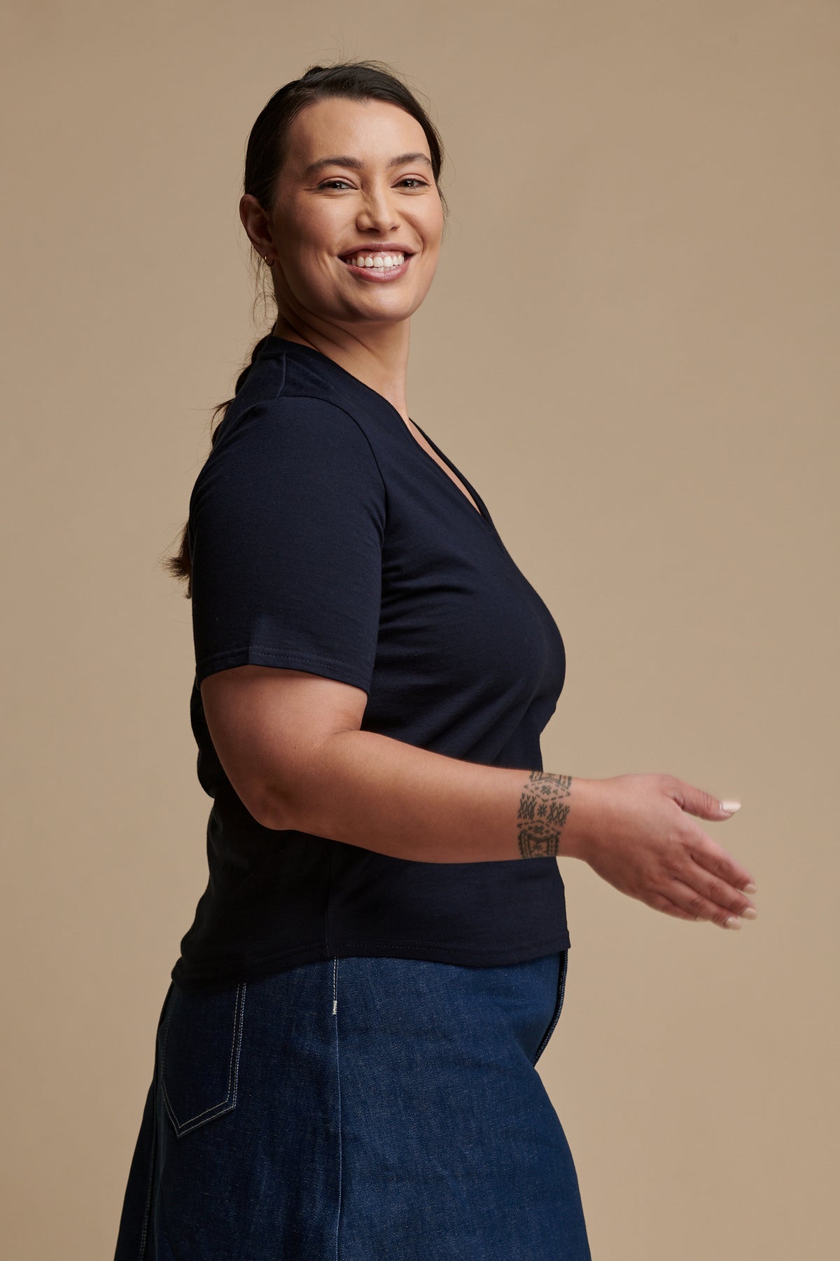 Thigh up of female wearing short sleeve v neck t shirt in navy paired with Bobbie a line midi skirt in blue 