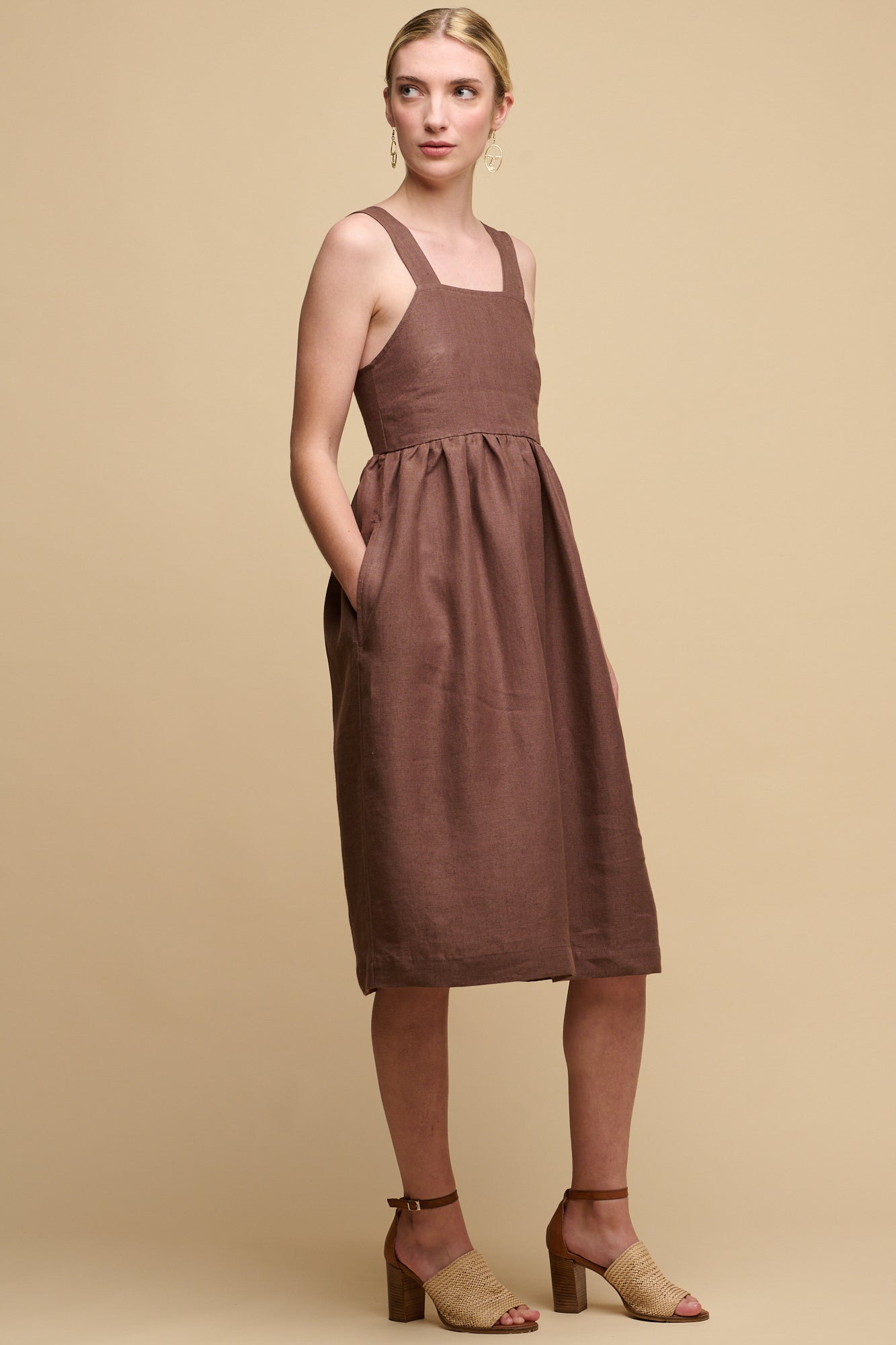 Full body shot of front of fair skinned female wearing sun dress in cocoa with her right hand in one of pockets