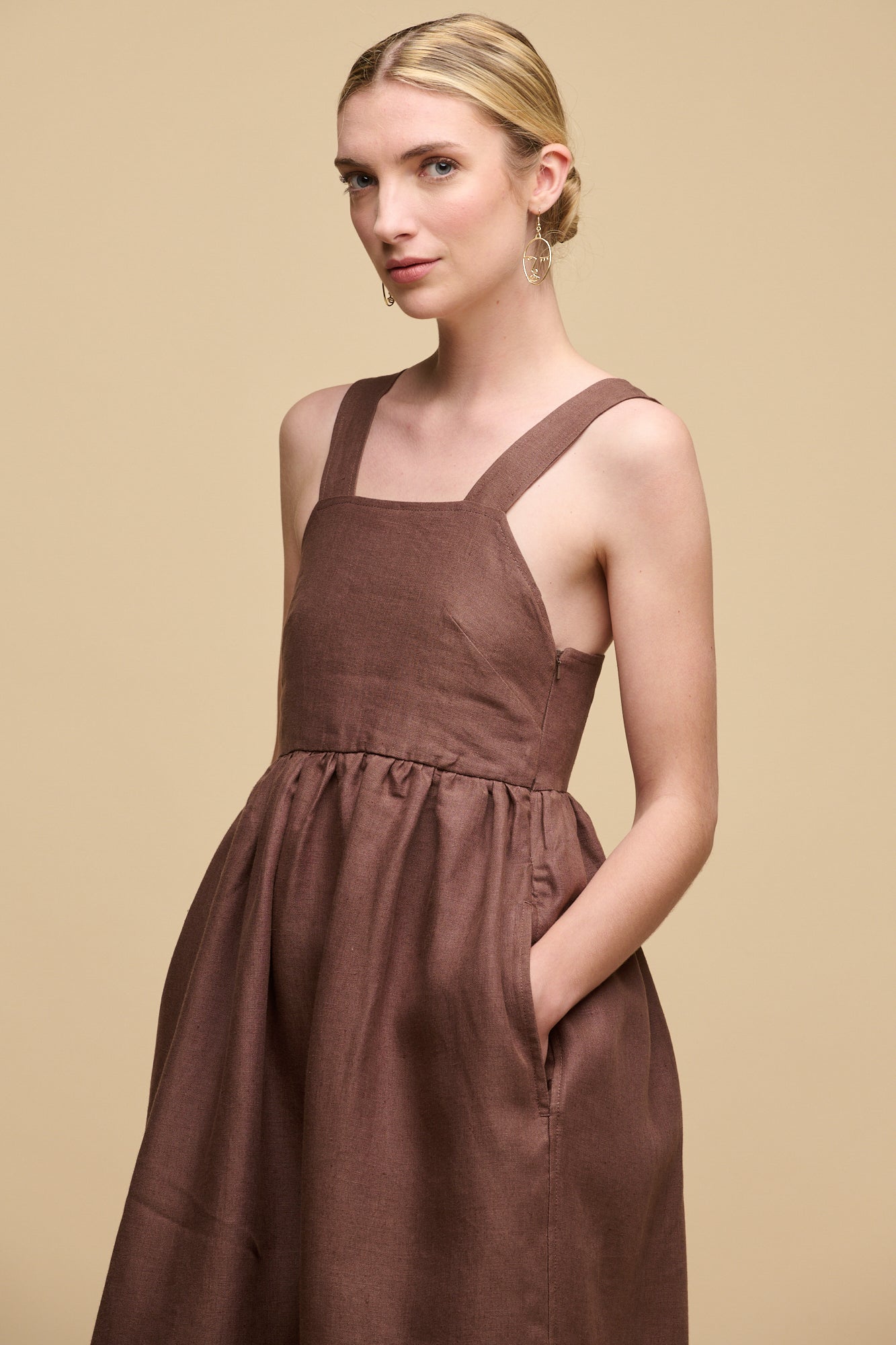 Thigh up image of blonde female wearing sun dress in cocoa