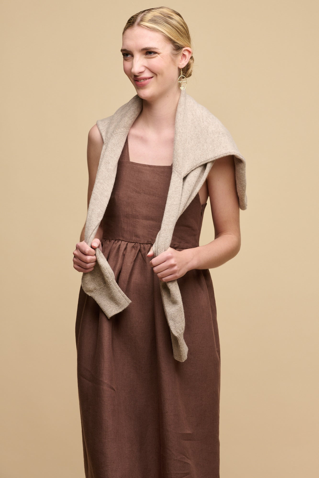 Full body shot of front of fair skinned female wearing sun dress in cocoa with her right hand in one of pockets