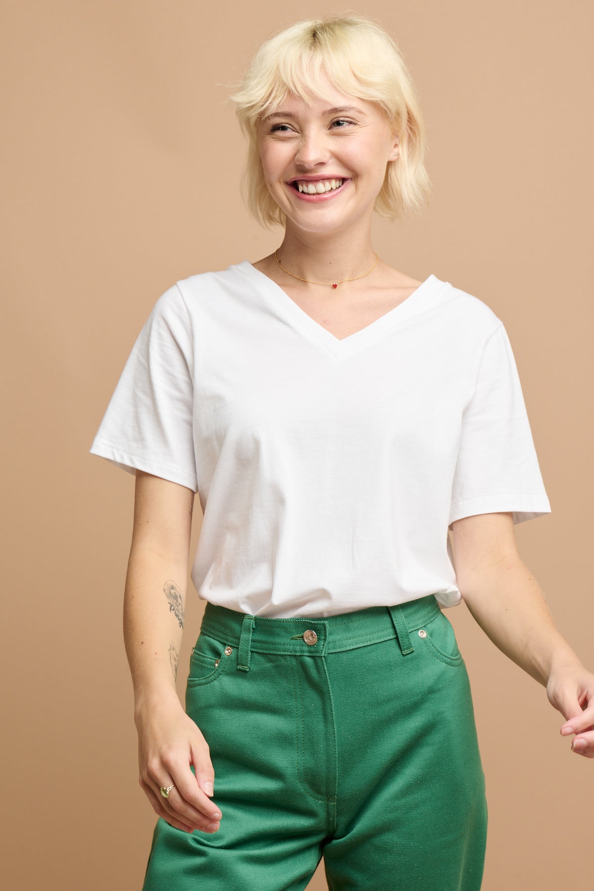 smiley female wearing community clothing v neck short sleeve t shirt in white