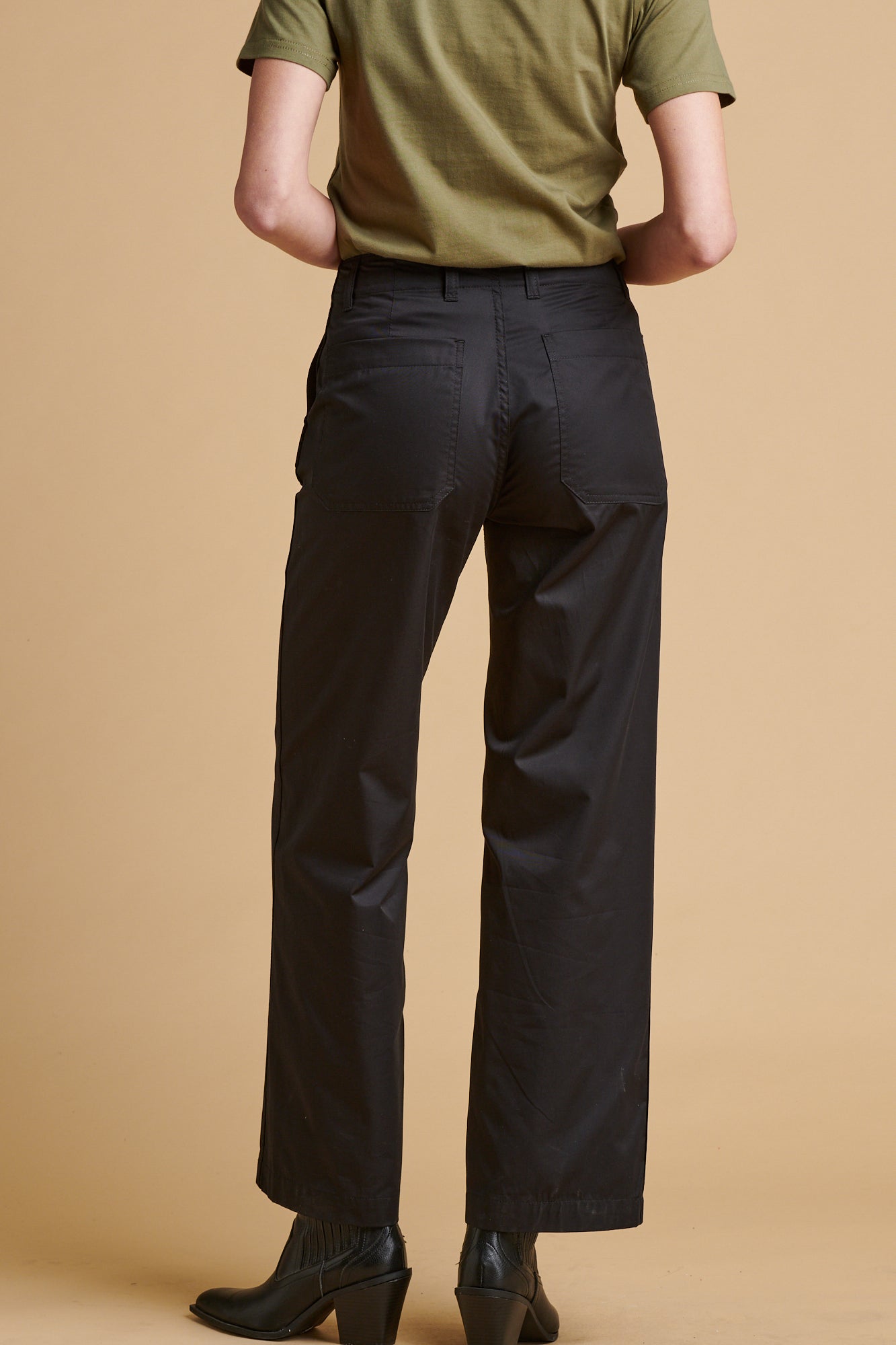 Female wearing lightweight work trousers in black.