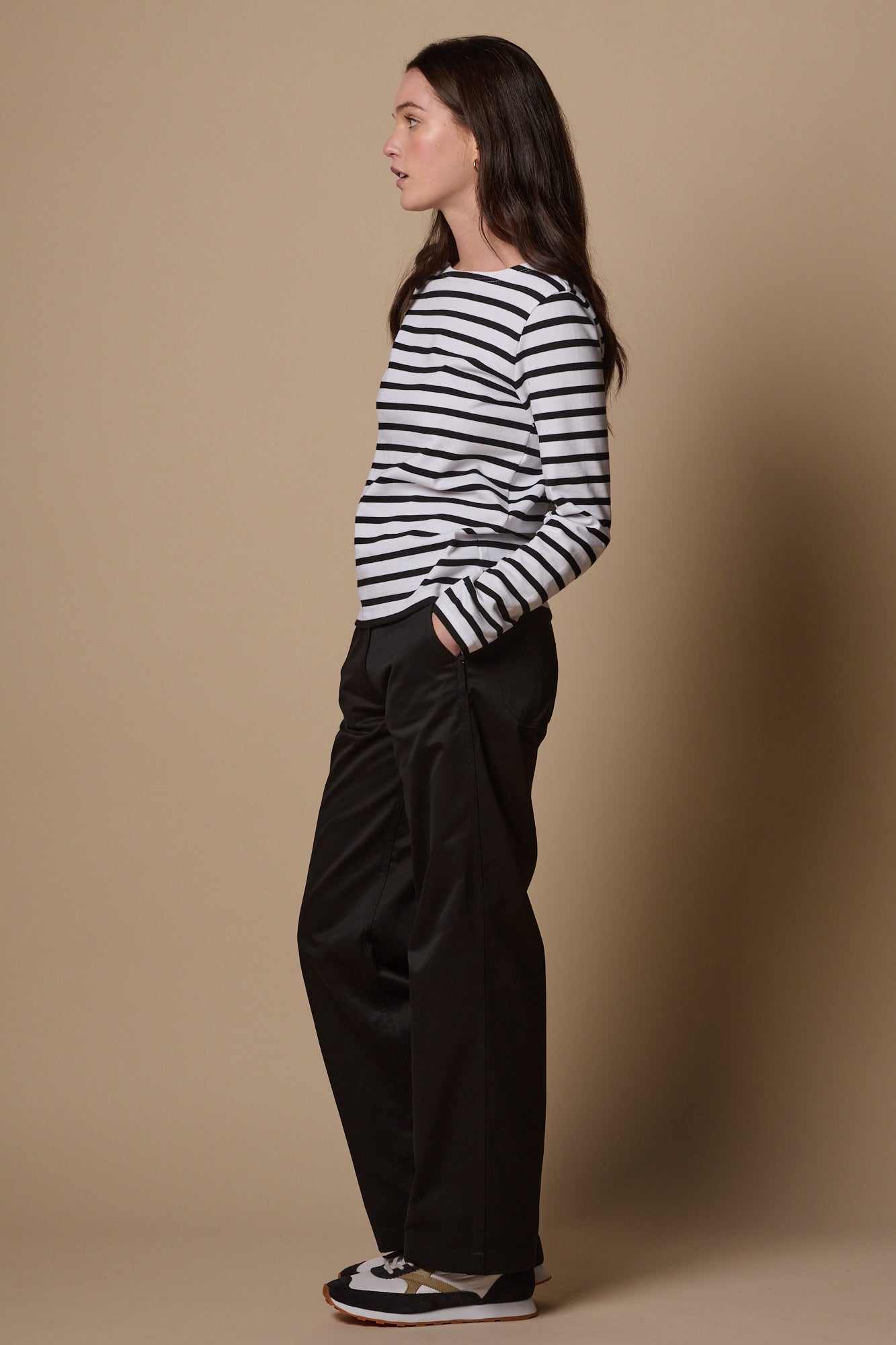 Shot of the side of female wearing work trousers in black with hand in front pocket