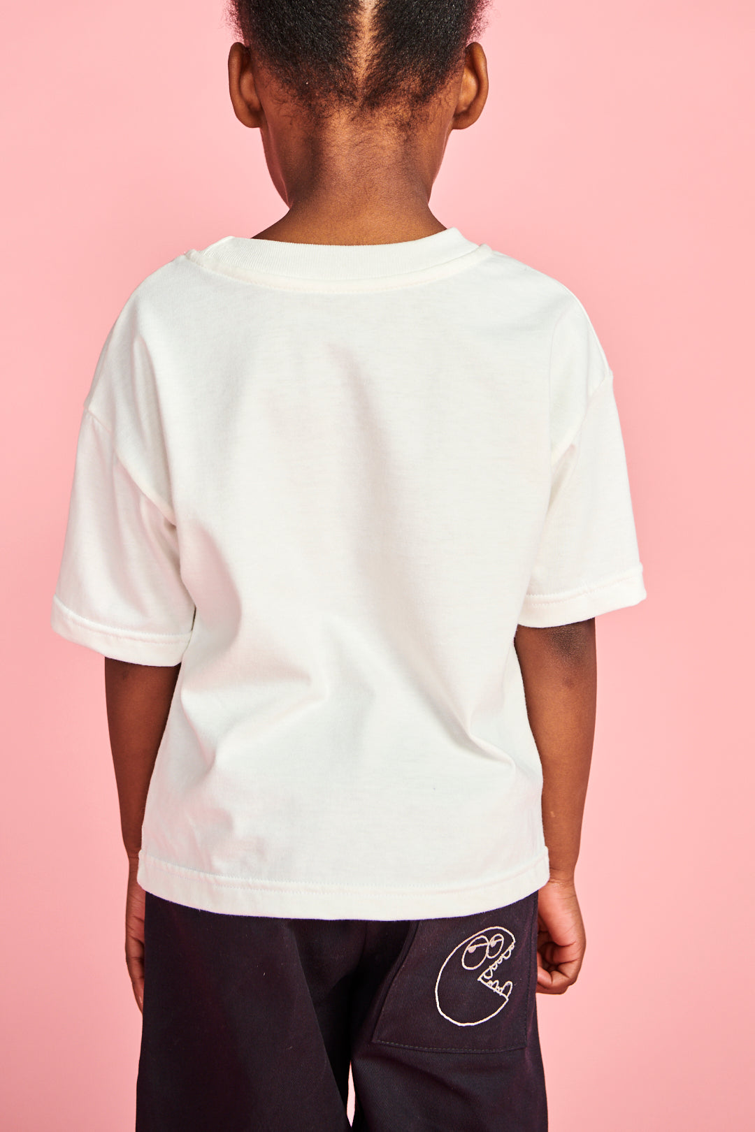 The back of young girl in plastic free short sleeve t shirt in bone 