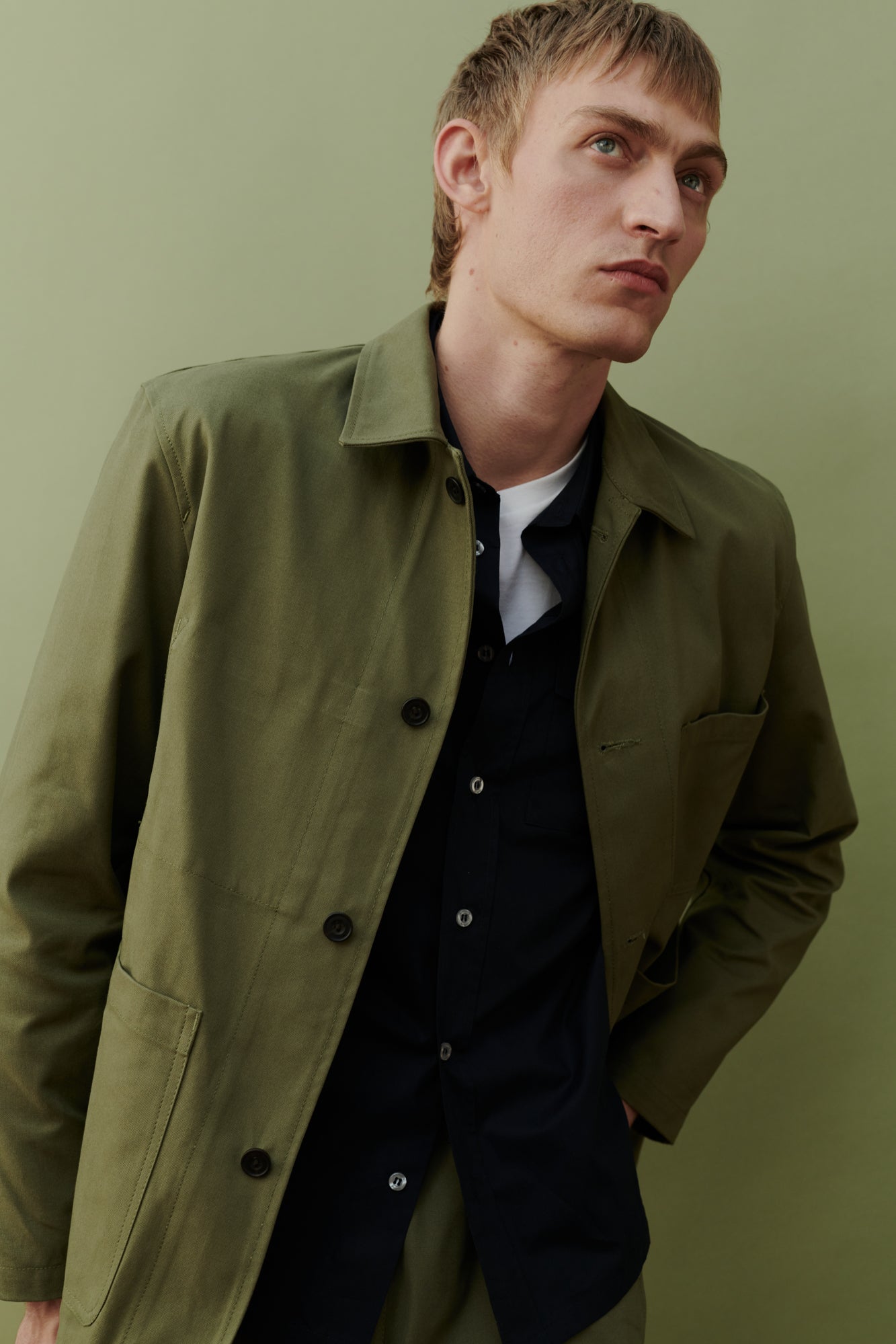 Image of white male, waist up wearing men's chore jacket in olive