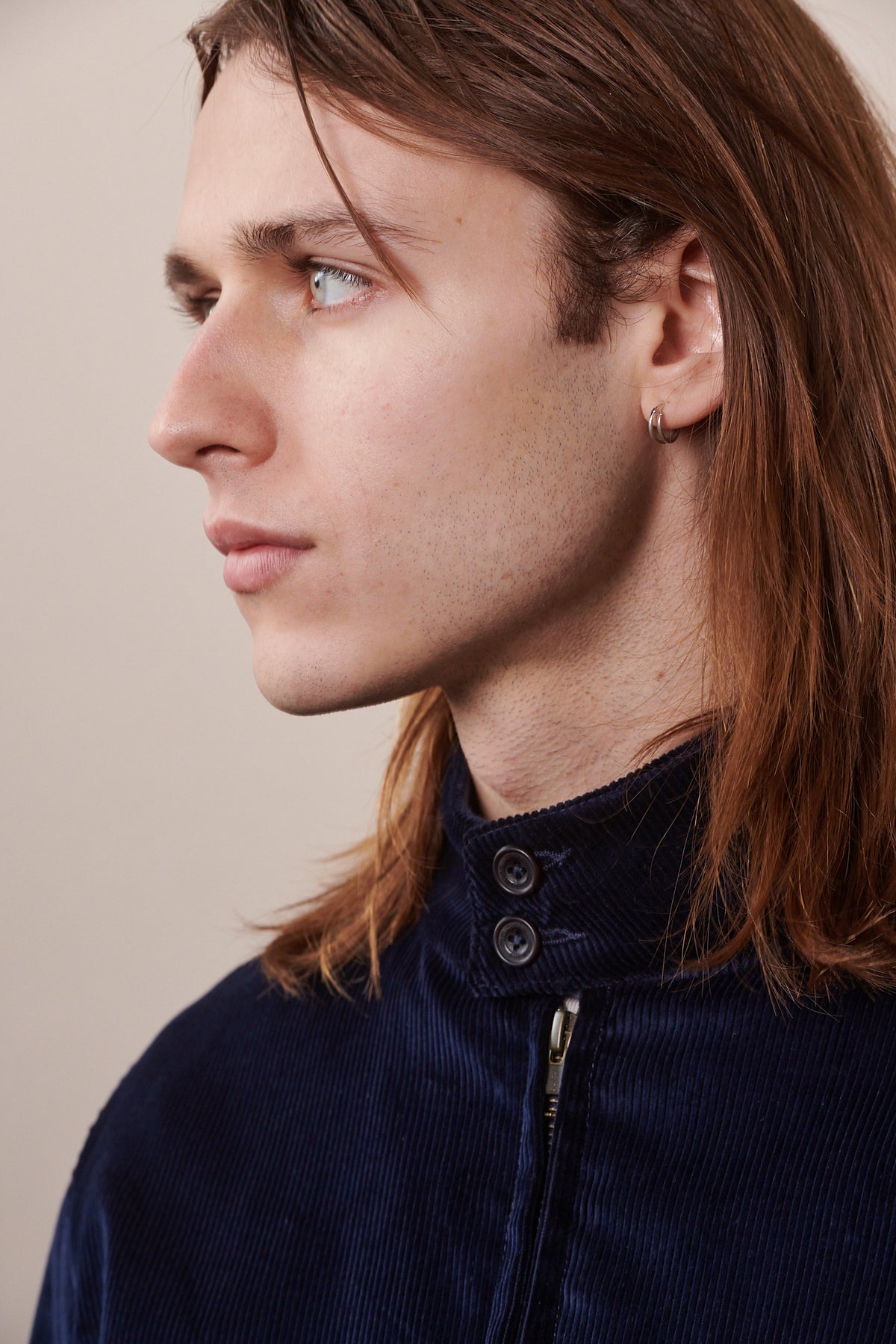 Portrait image of male showing close up of collar of the corduroy Harrington in navy 