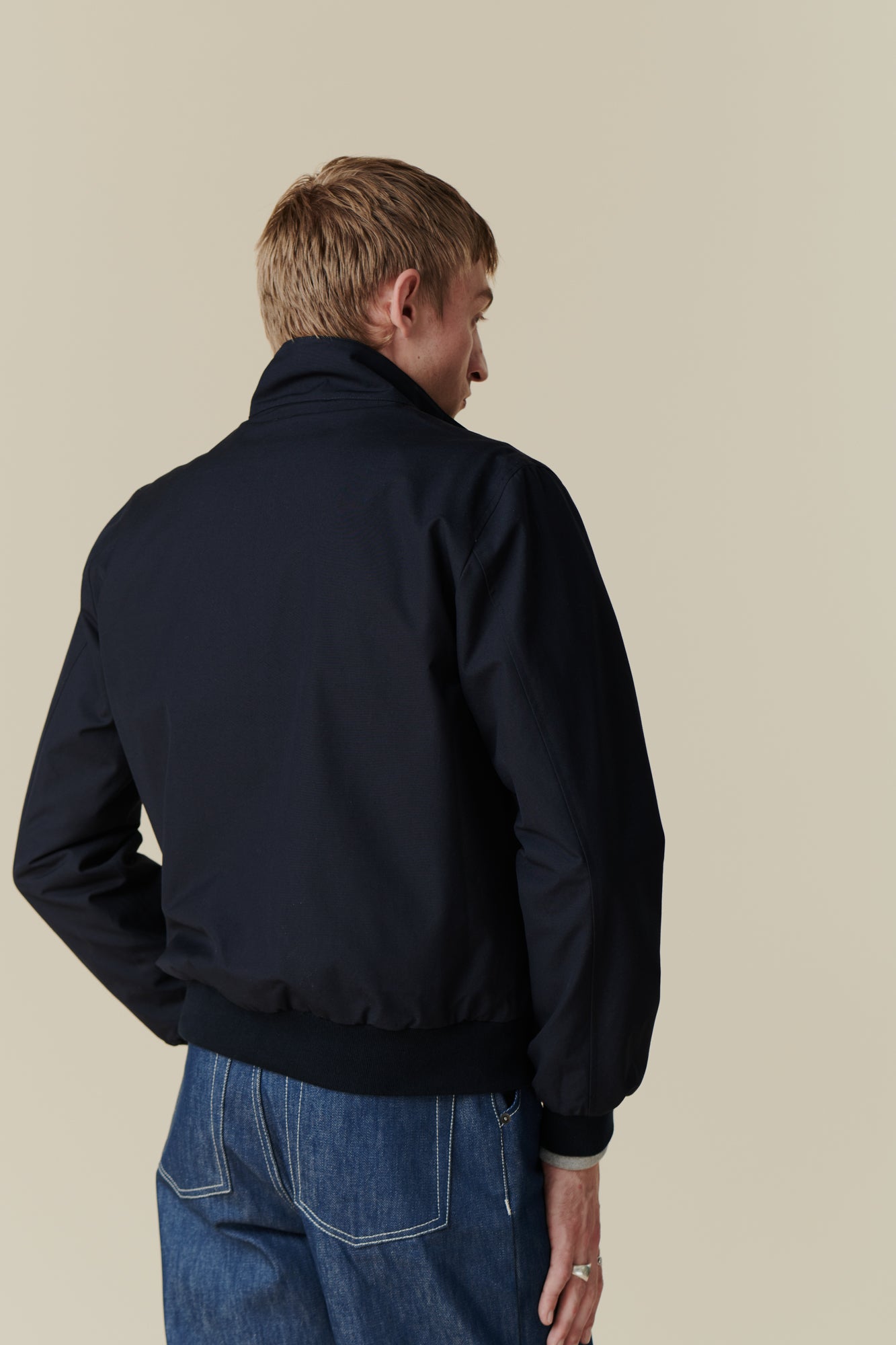 Back of white male wearing men's Harrington jacket in navy
