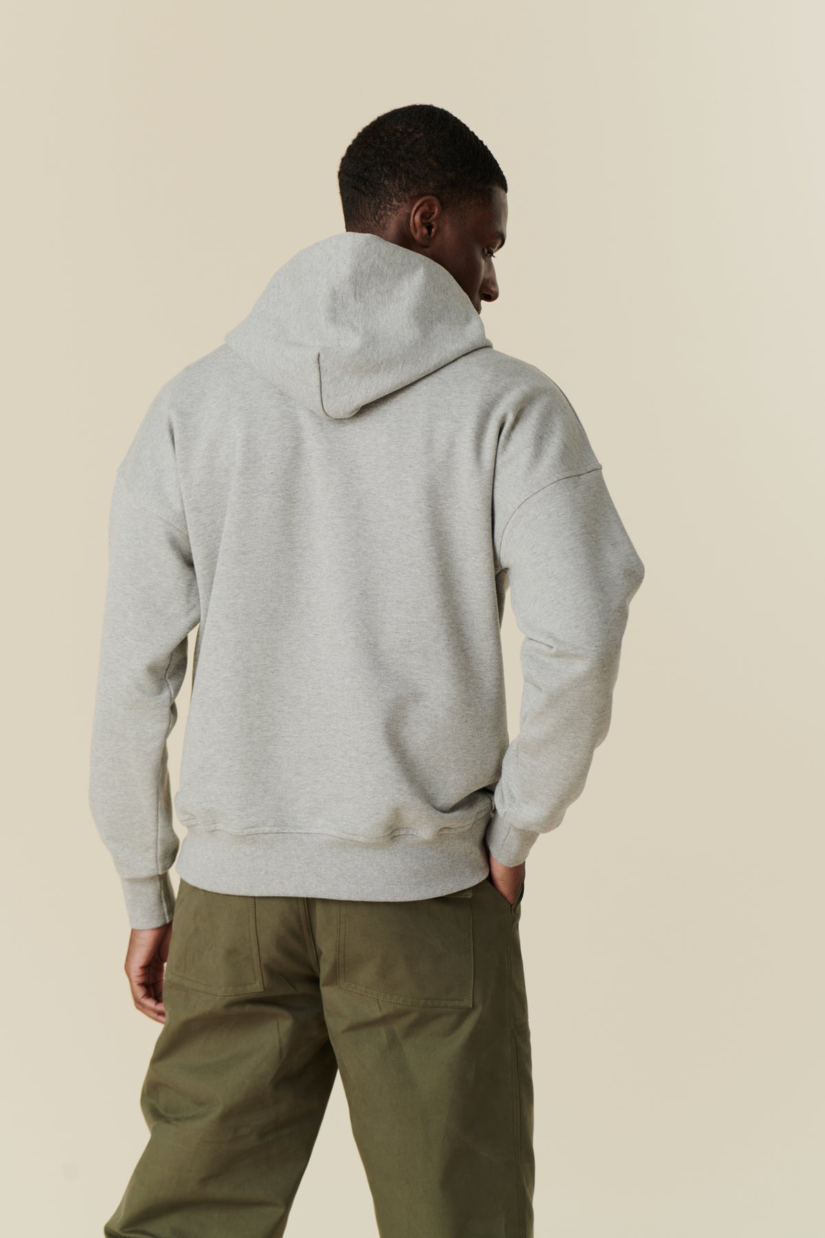 back of Male wearing wearing hooded sweatshirt in grey 