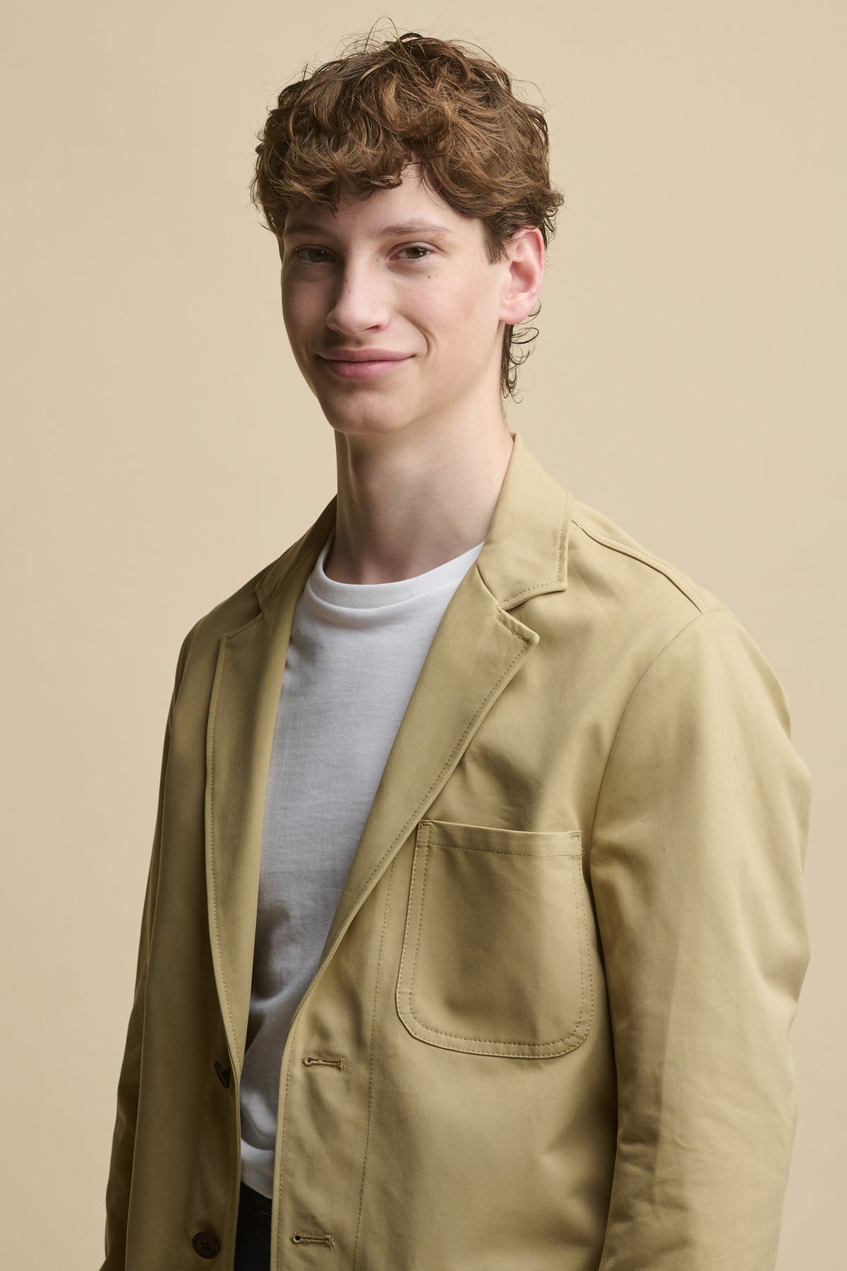 Waist up image of male wearing Men's James Single Breasted Blazer in stone over a short sleeve white t shirt