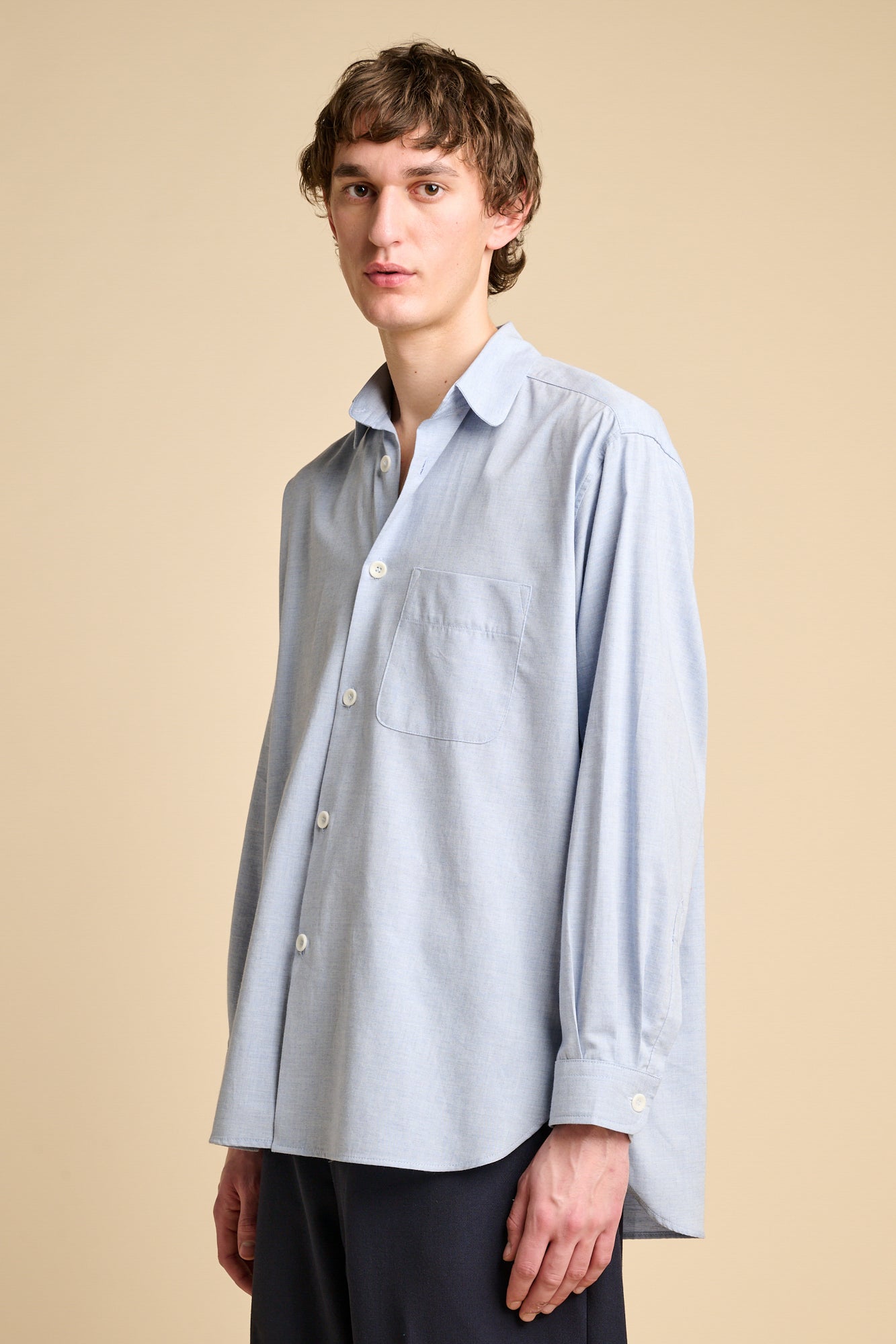 A man wearing long sleeve light blue shirt.