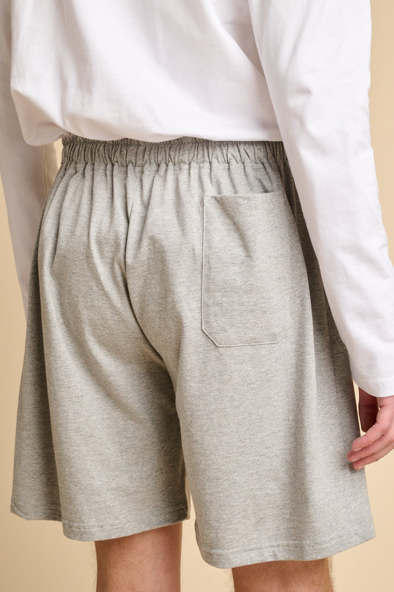 The back of man wearing grey marl jersey shorts.