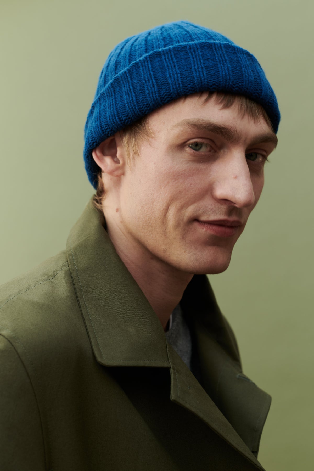 Male wearing unisex lambswool beanie hat in bright blue