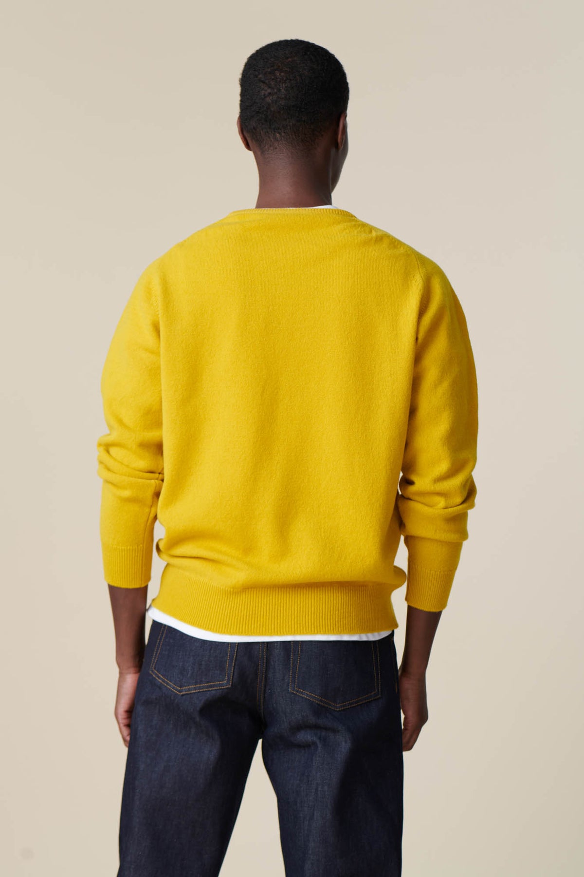 Back of male wearing lambswool crew neck in picalilli yellow