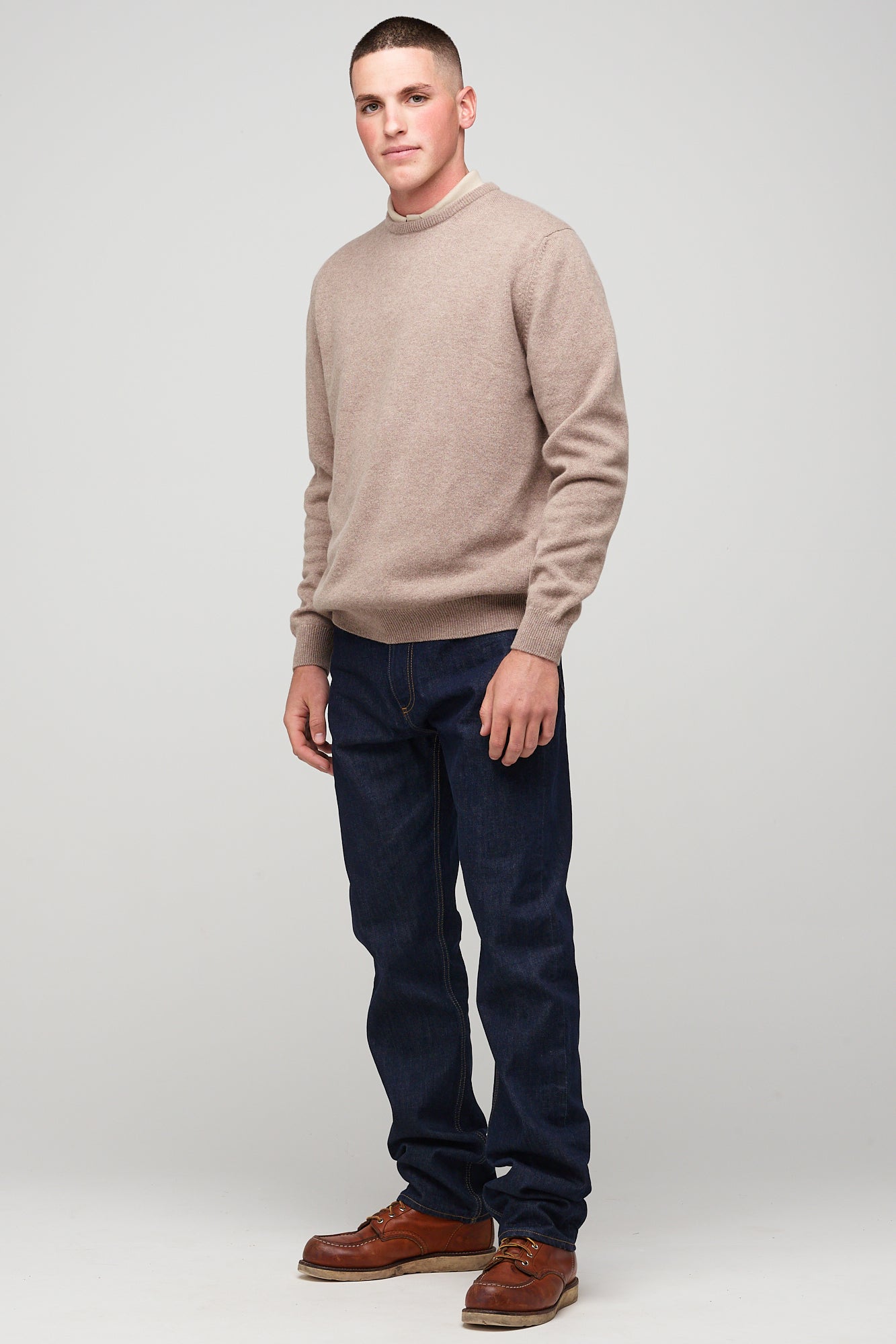 brunette, white male in taupe lambswool crew neck, styled with denim jeans