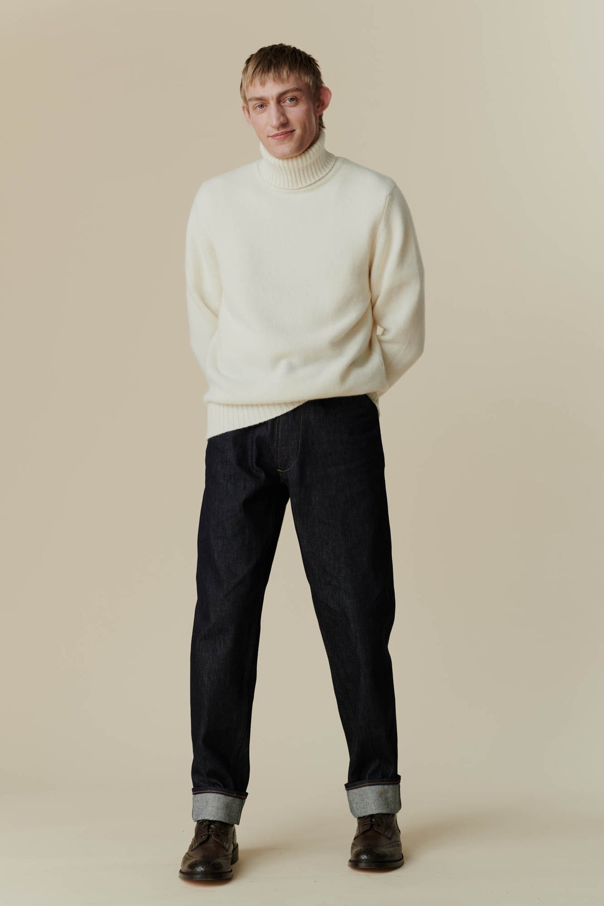 Full body shot of white male wearing lambswool roll neck in ecru