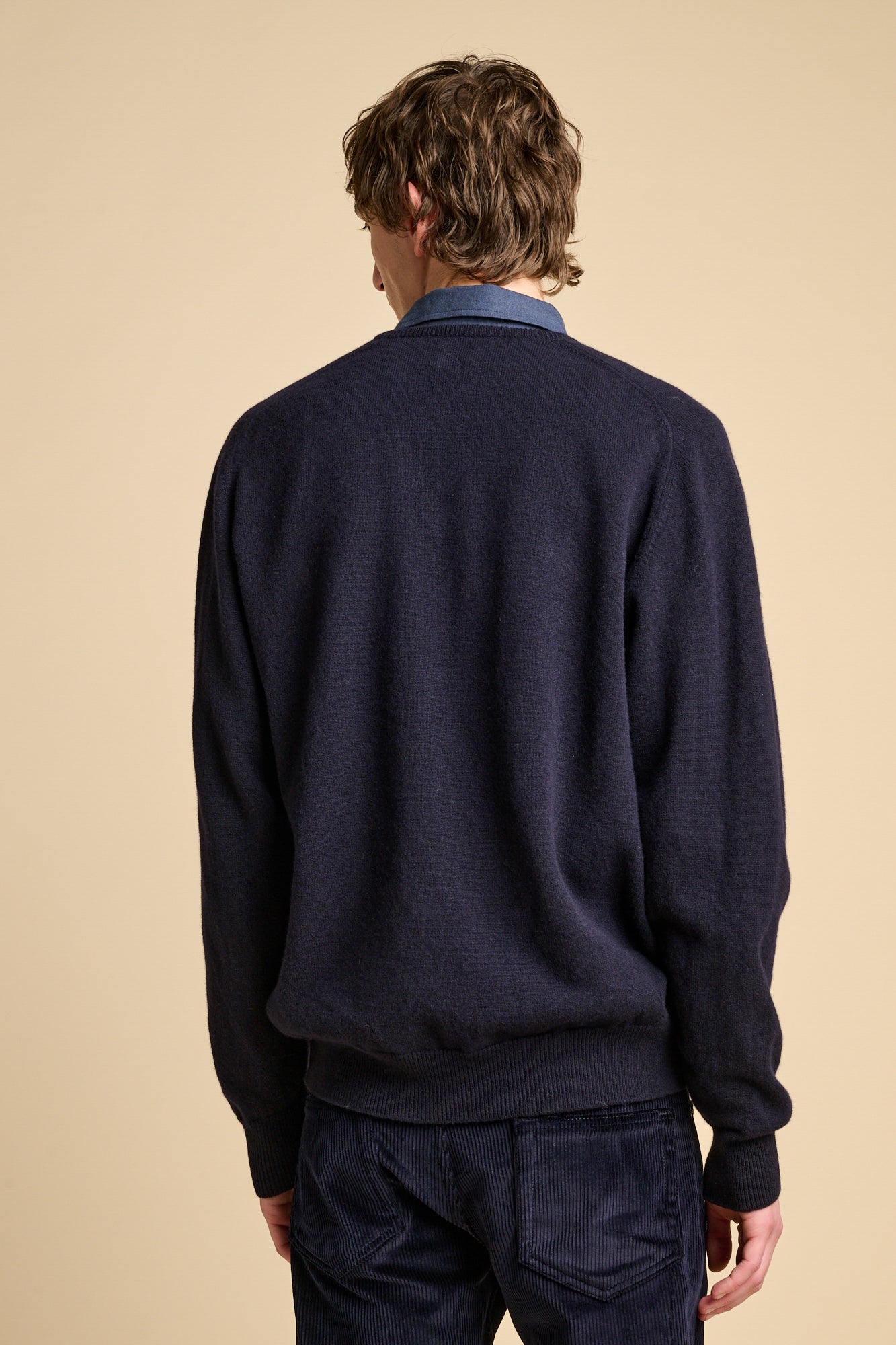Back of male wearing lambswool jumper in navy