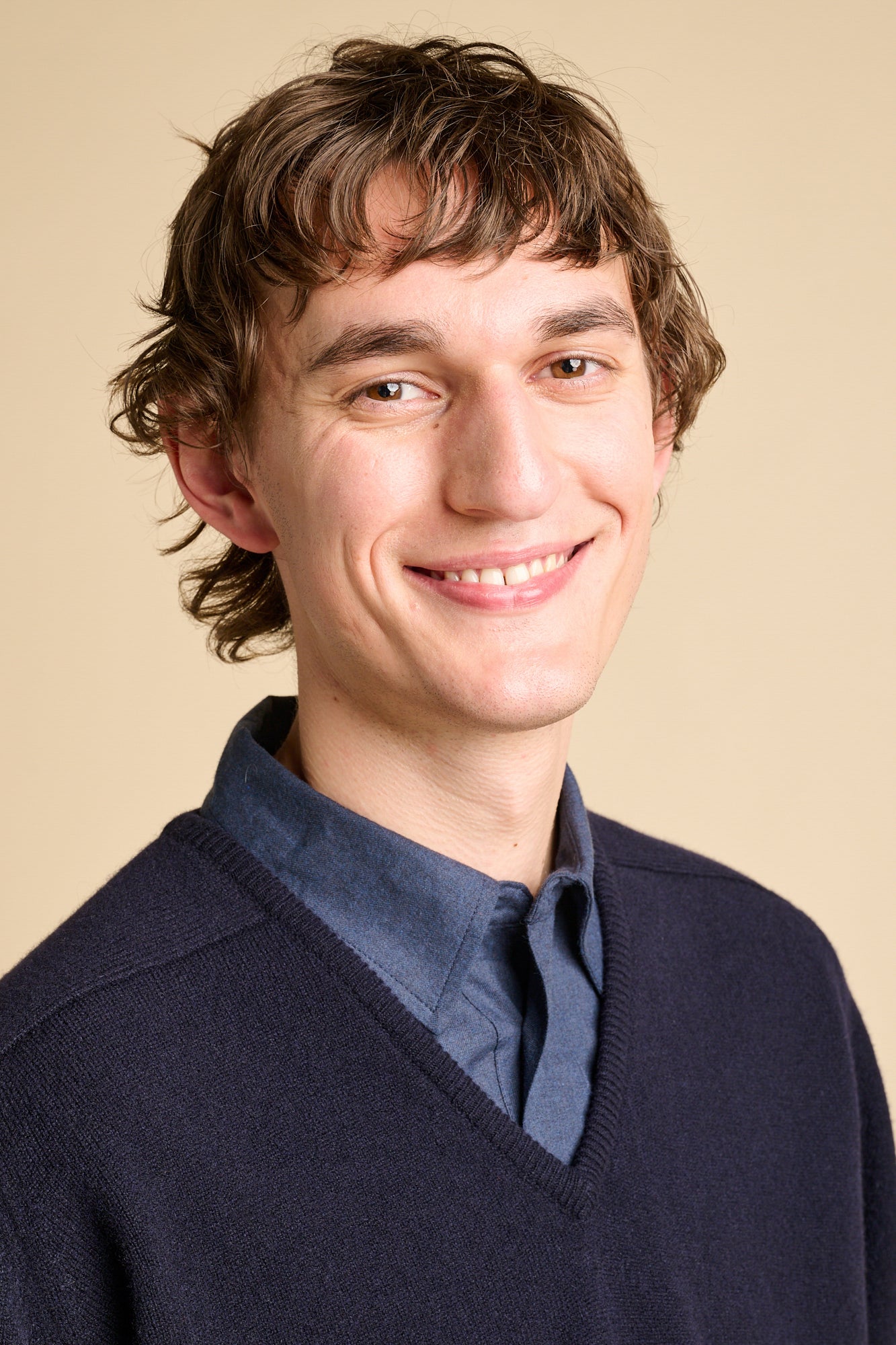 male wearing v neck jumper over shirt