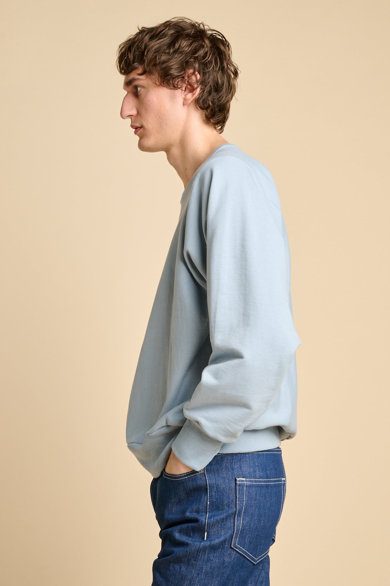 Man wearing sky blue oversized crew neck sweatshirt with jeans. 