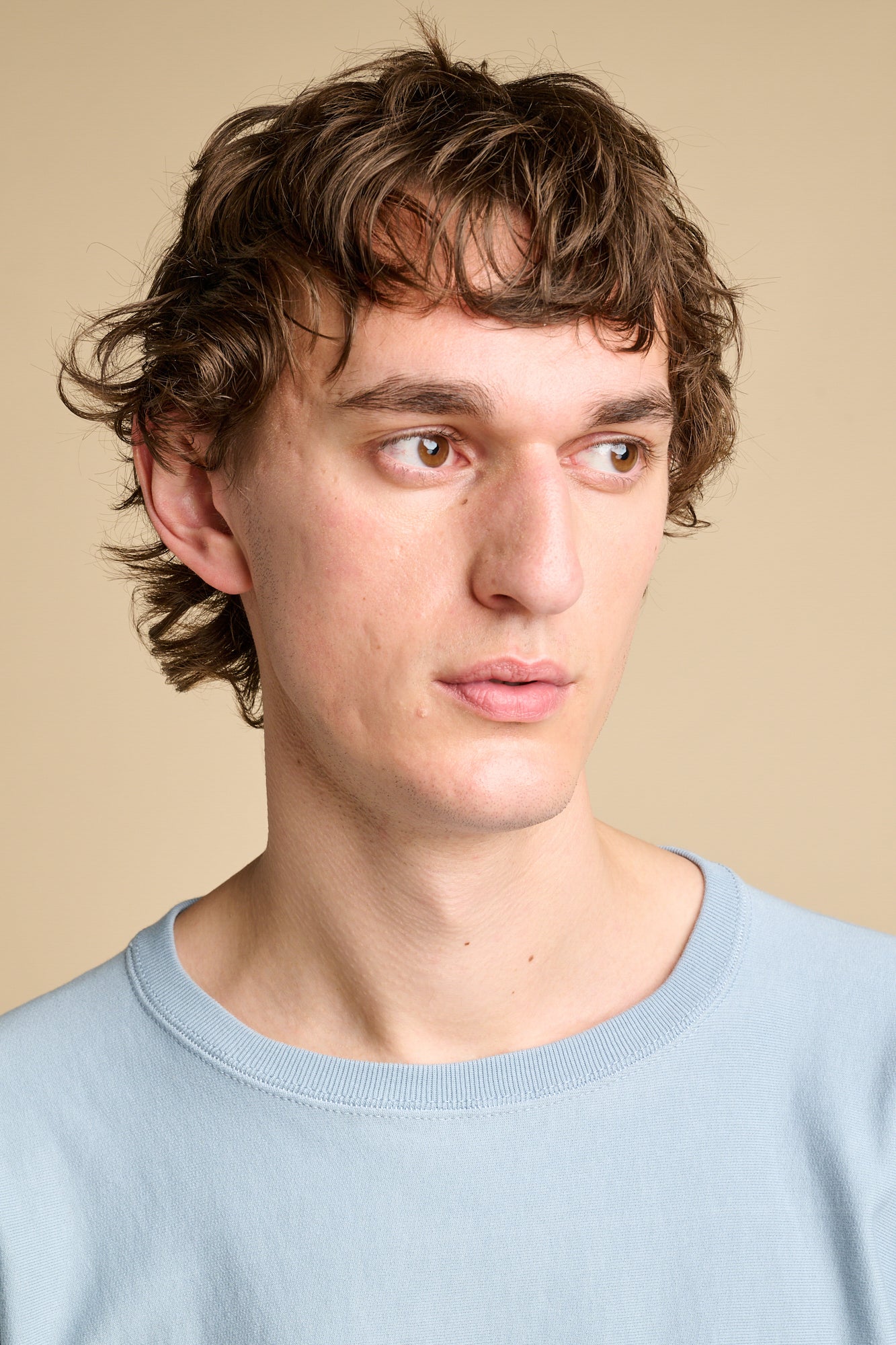 Portrait of man wearing crew neck sweatshirt in sky blue.